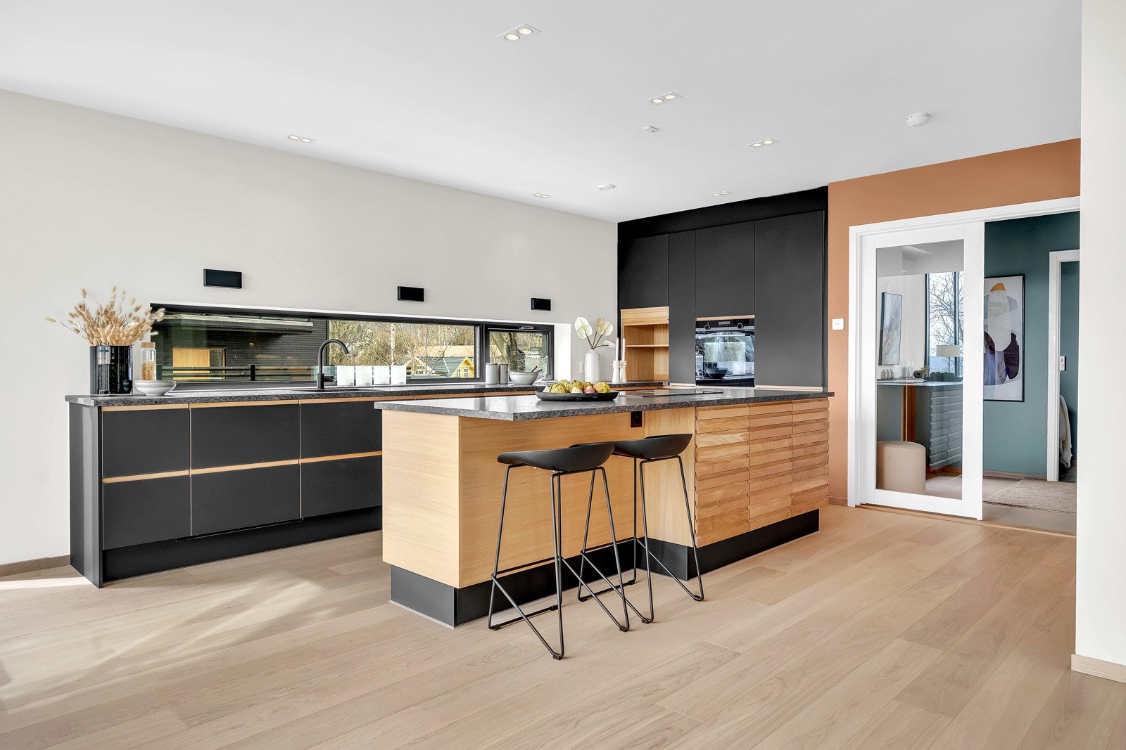 Delikat kjøkken levert av JKE type Inline - legg merke til delikat belysning over kjøkkenbenken Galleribilde