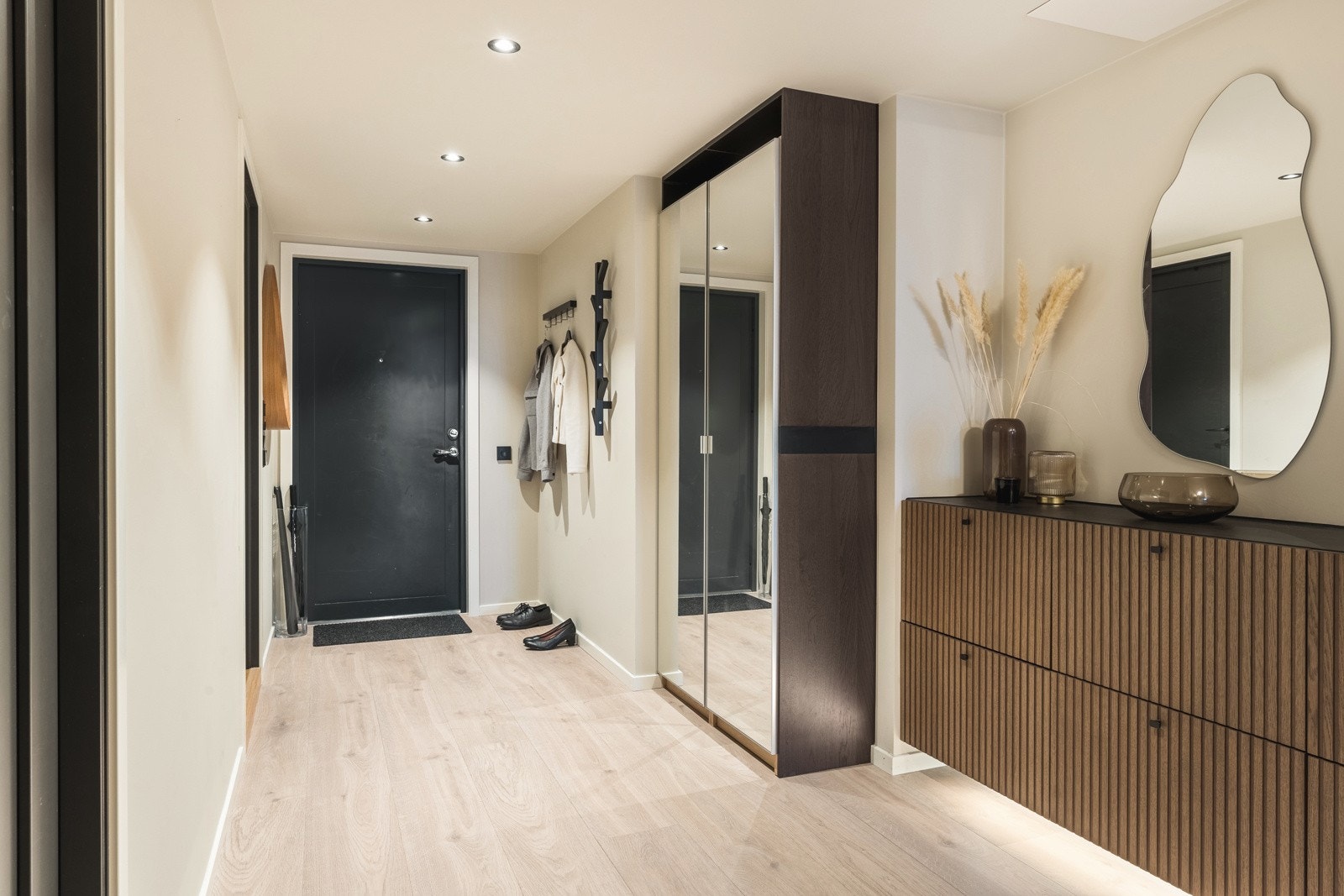 Velkommen inn til leilighetens entré med moderne fargetoner og innfelte downlights. Entreen har rikelig med oppbevaringsplass i garderobeskap og på vegghengte knagger. Galleribilde