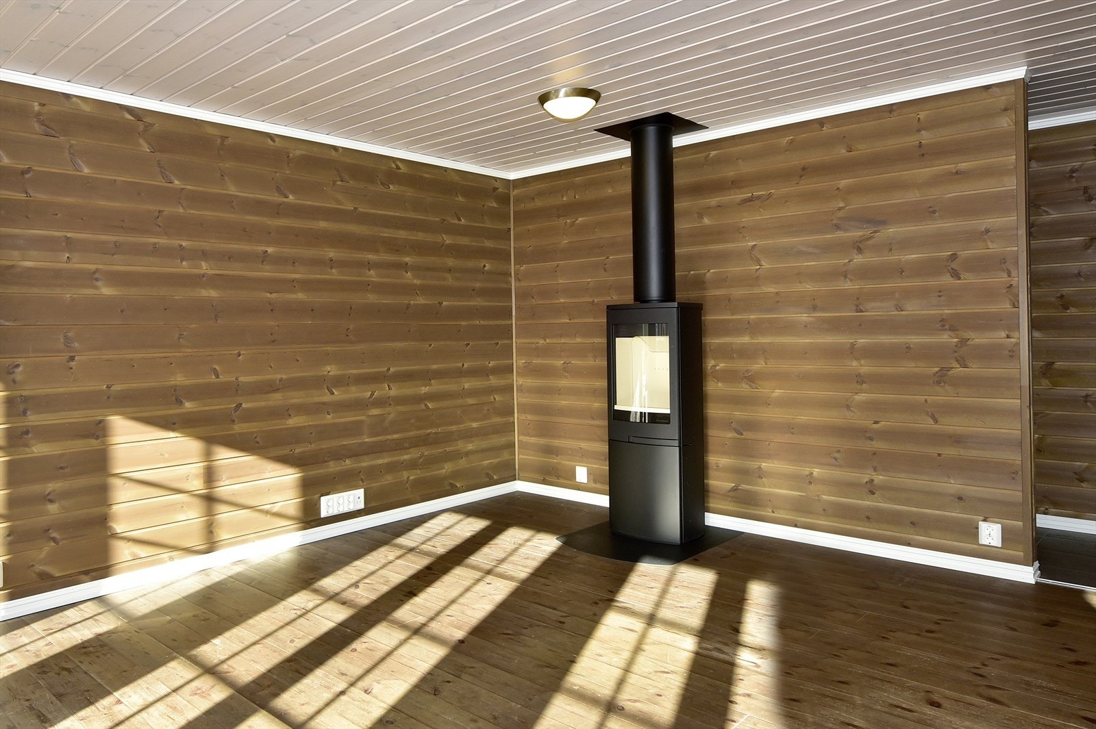 Stuen har vedovn som avgir behagelig varme i hytta Galleribilde