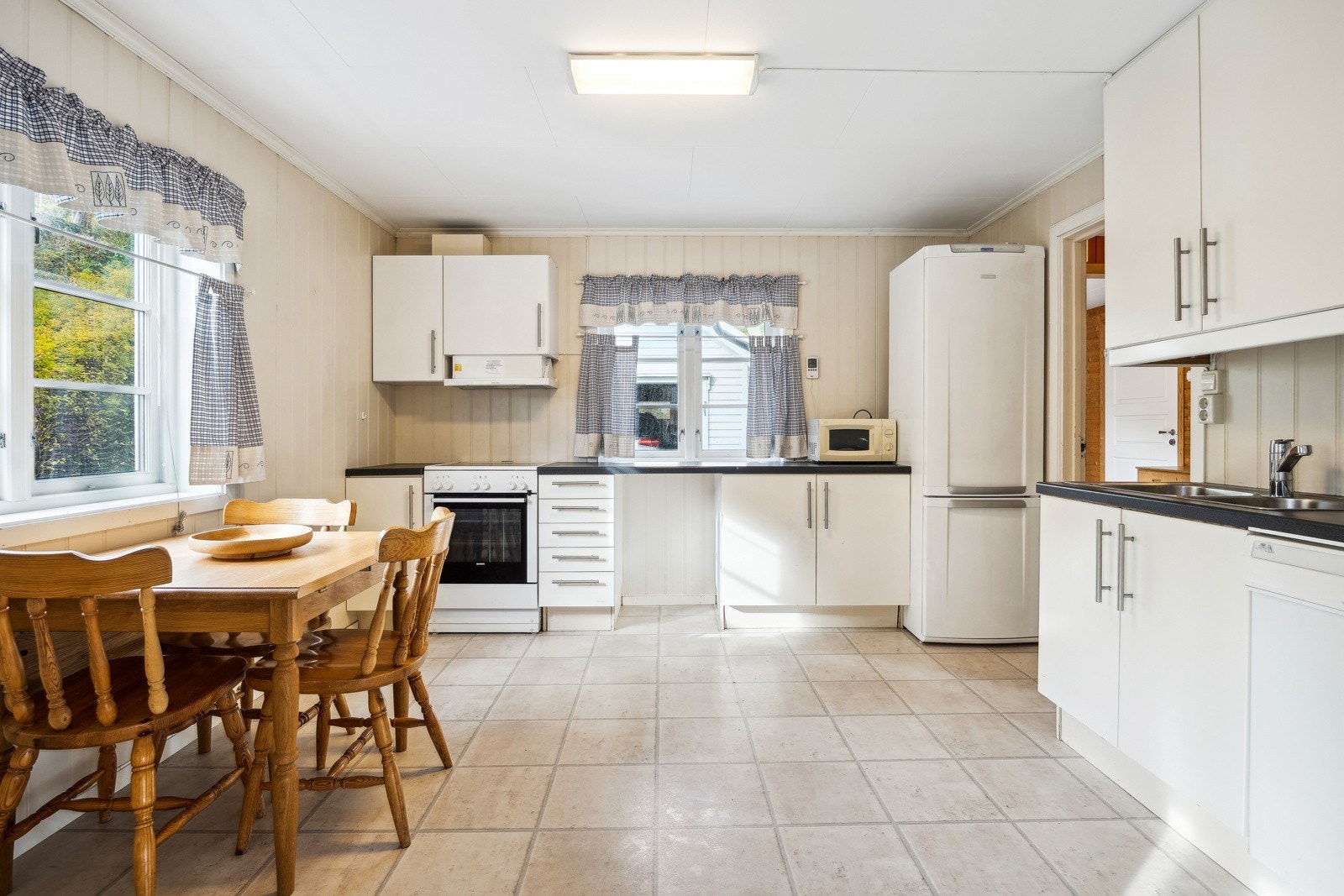 Kjøkken i 1. etasje. Lys kjøkkeninnredning med profilerte fronter. Galleribilde