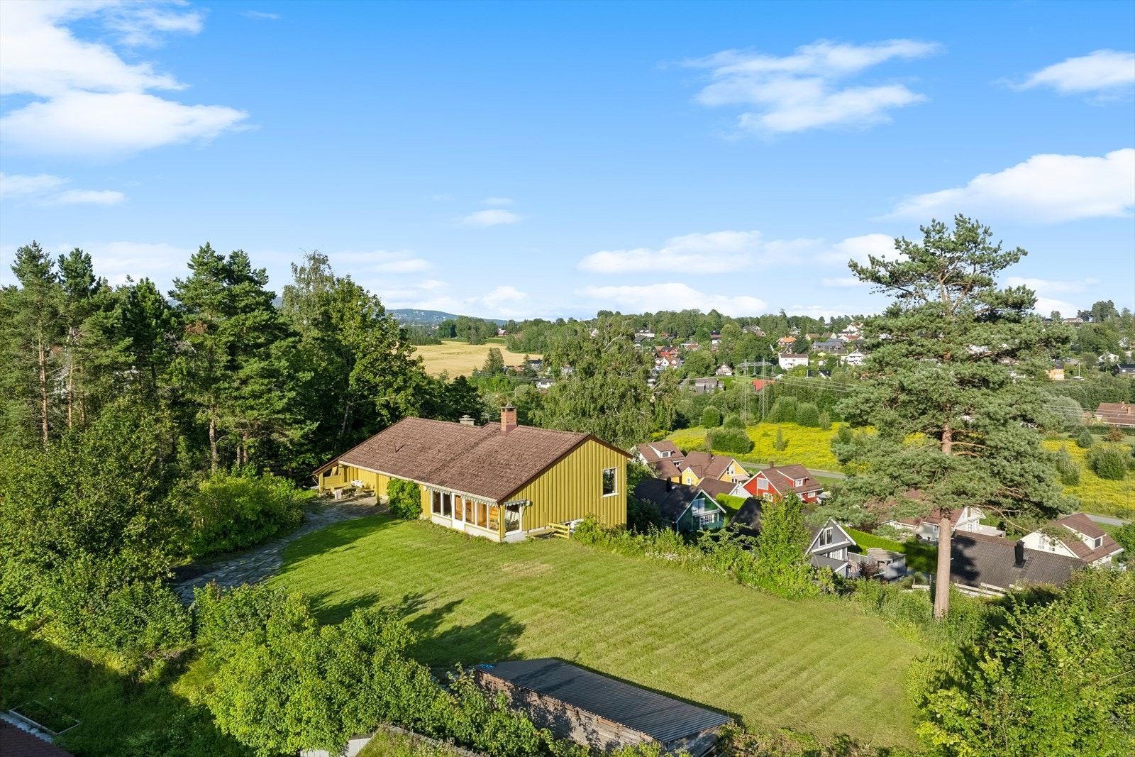 Tomten på hele 3.160 kvm ligger høyt og fritt med flott sol- og utsiktsforhold Galleribilde