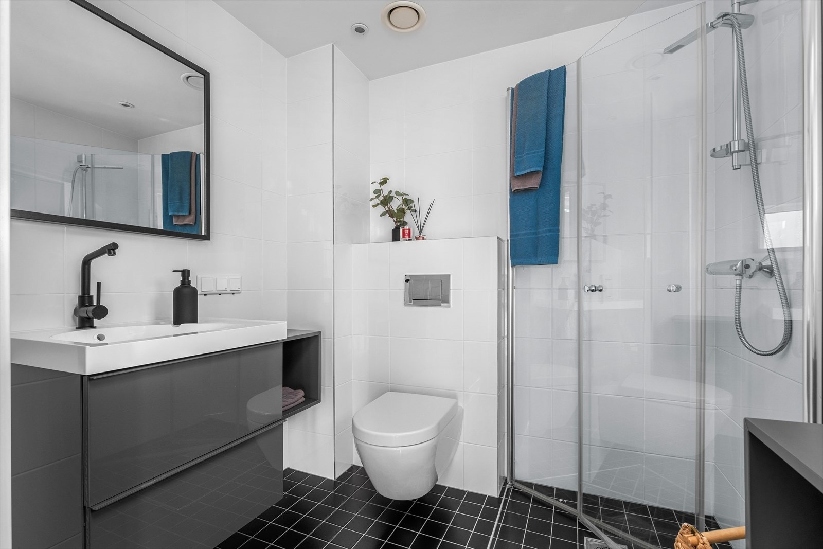 Badet i tredje etasje har dusjhjørne med rette, innfellbare glassdører og et noe mindre møblement enn på badet nede. Galleribilde