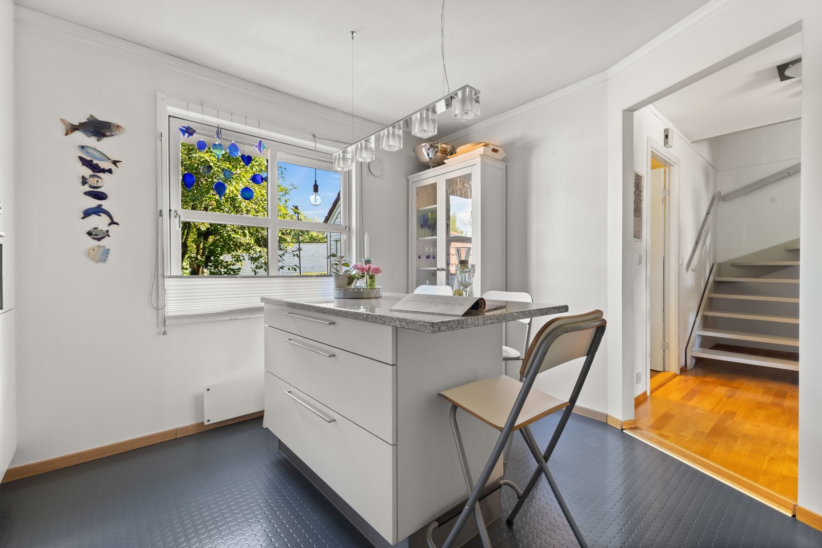 Kjøkkenet får inn godt med lysinnslipp og ser ut over inngangsparti med grønne omgivelser. Galleribilde