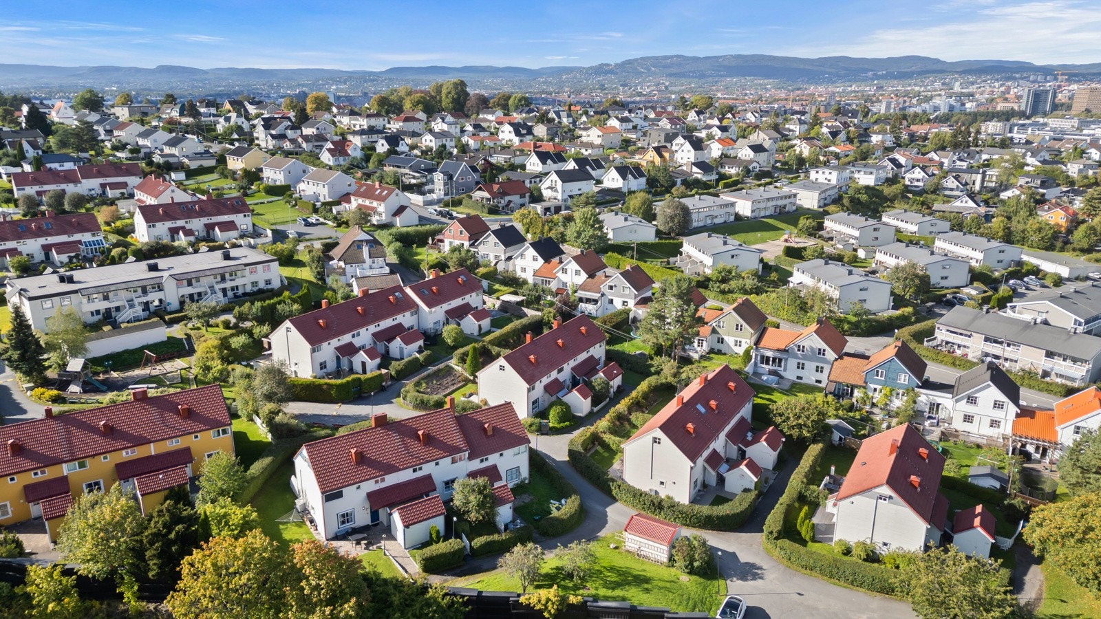 Området har bilfrie internveier og et opparbeidet tun med velutstyrt lekeplass og sittebenker Galleribilde