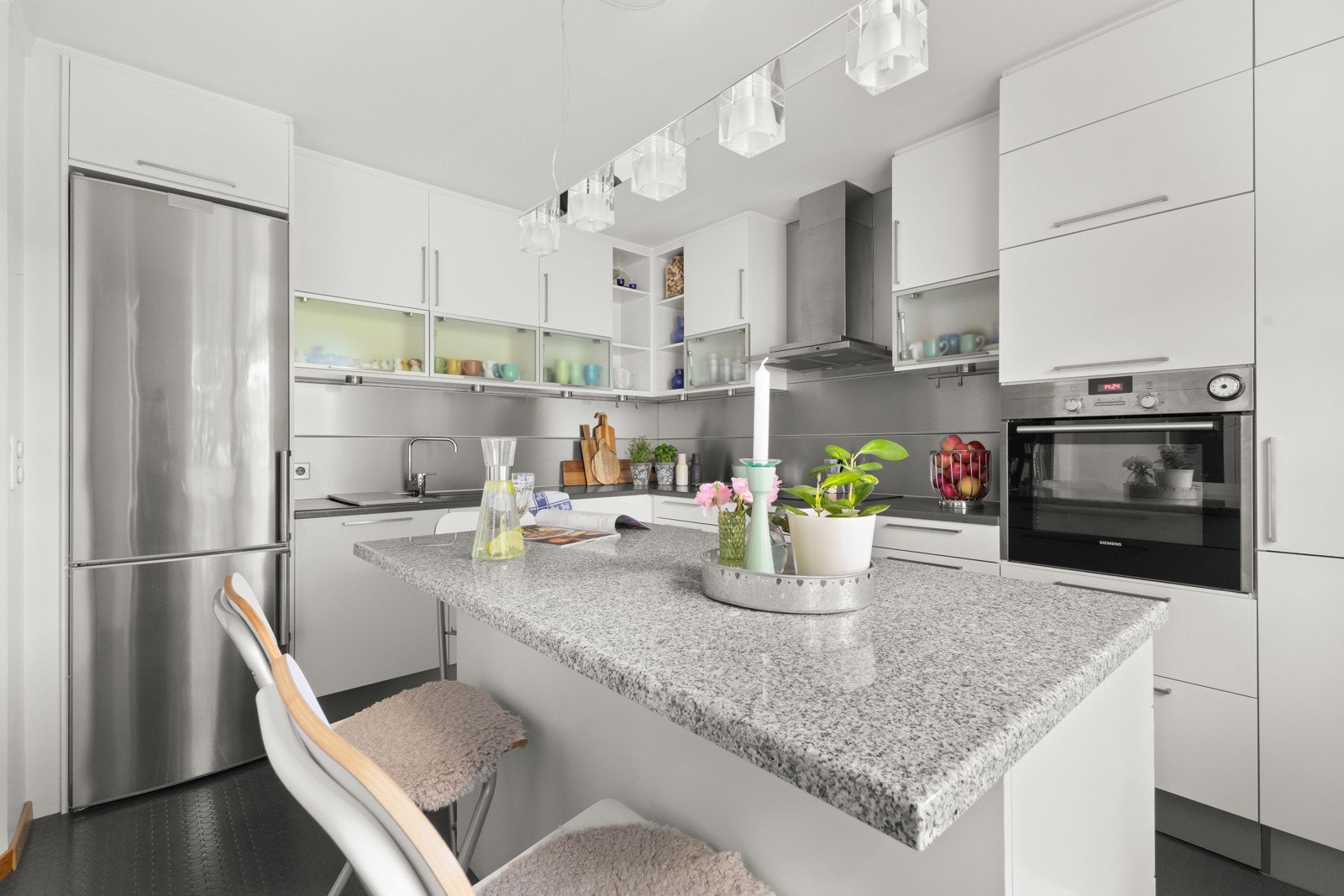 Kjøkken fra 2009 med industrielt preg, kjøkkenøy, gode benkeflater og mye oppbevaringsplass Galleribilde