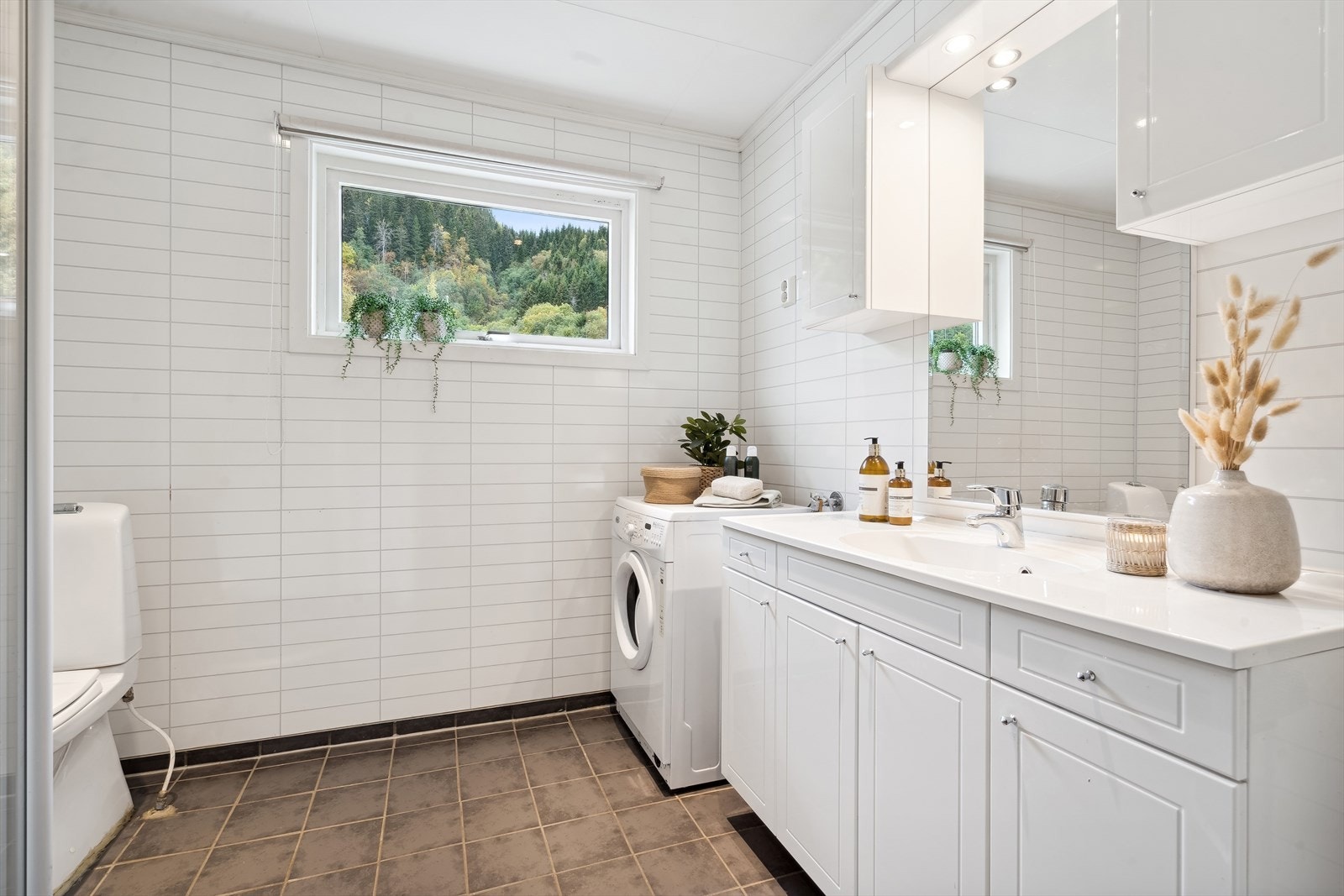 Badet i første er fra 2012 og har godt med oppbevaringsplass i stor, hvit innredning. Galleribilde