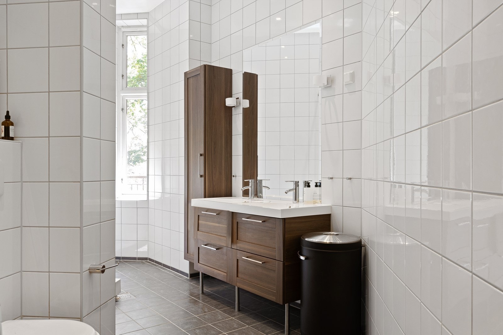 Boligen har to bad som er tidløst og pent flislagt. Hovedbadet er innredet med stor servantinnredning, vegghengt skap, klosett og dusjkabinett. Vinduet sørger for rikelig med dagslys Galleribilde