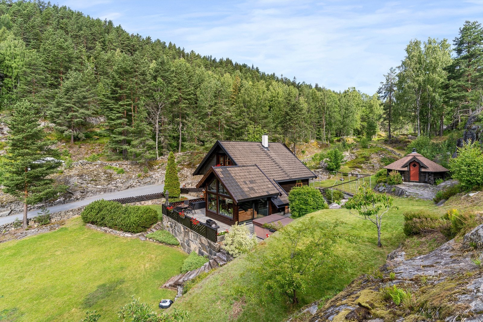 Terrenget rundt boligen går over flere plan med flere herlige områder. Du har også en flott grillhytte. Galleribilde