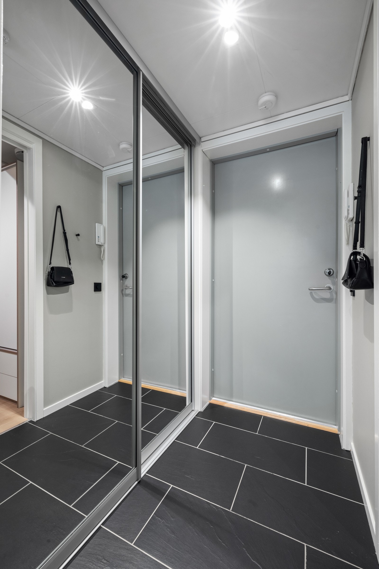 Ved entrédøren er det montert dørcalling og en smart skyvedørsgarderobe Galleribilde