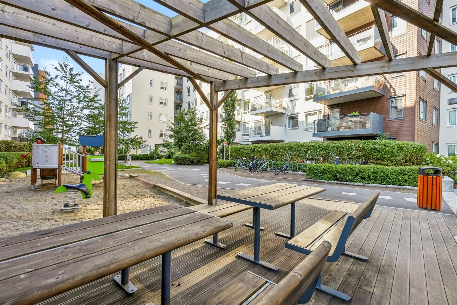 Tomten er pent og parkmessig opparbeidet med variert beplantning, lekeplass og sitteplasser Galleribilde