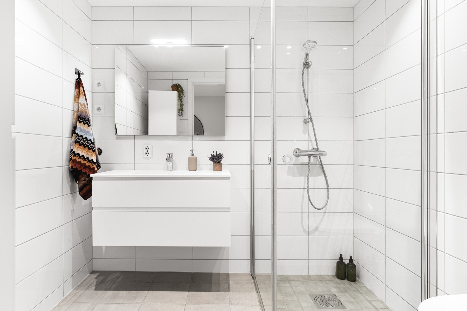 Helfliset bad med varme i gulv. Badet er innredet med baderomsinnredning med nedfelt servannt, vegghengt toalett og dusjhjørne. Galleribilde