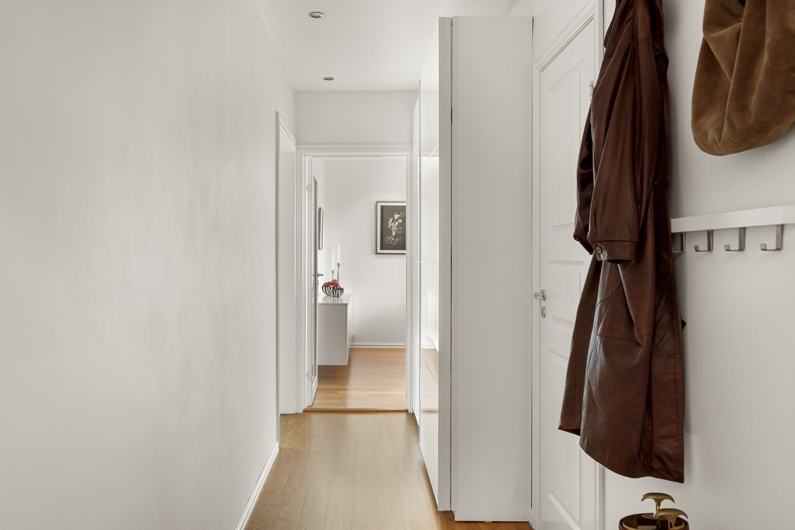 Innbydende entré som gir et godt førsteinntrykk. Her er det godt med plass for oppbevaring i stor skyvedørsgarderobe Galleribilde