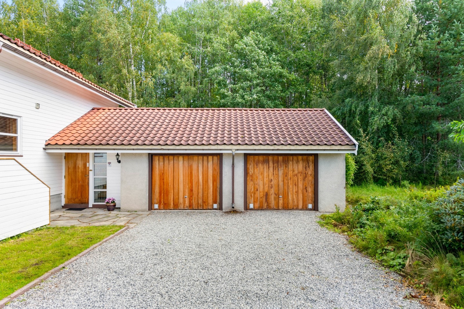 Stor, gruset gårdsplass og dobbeltgarasje. Galleribilde