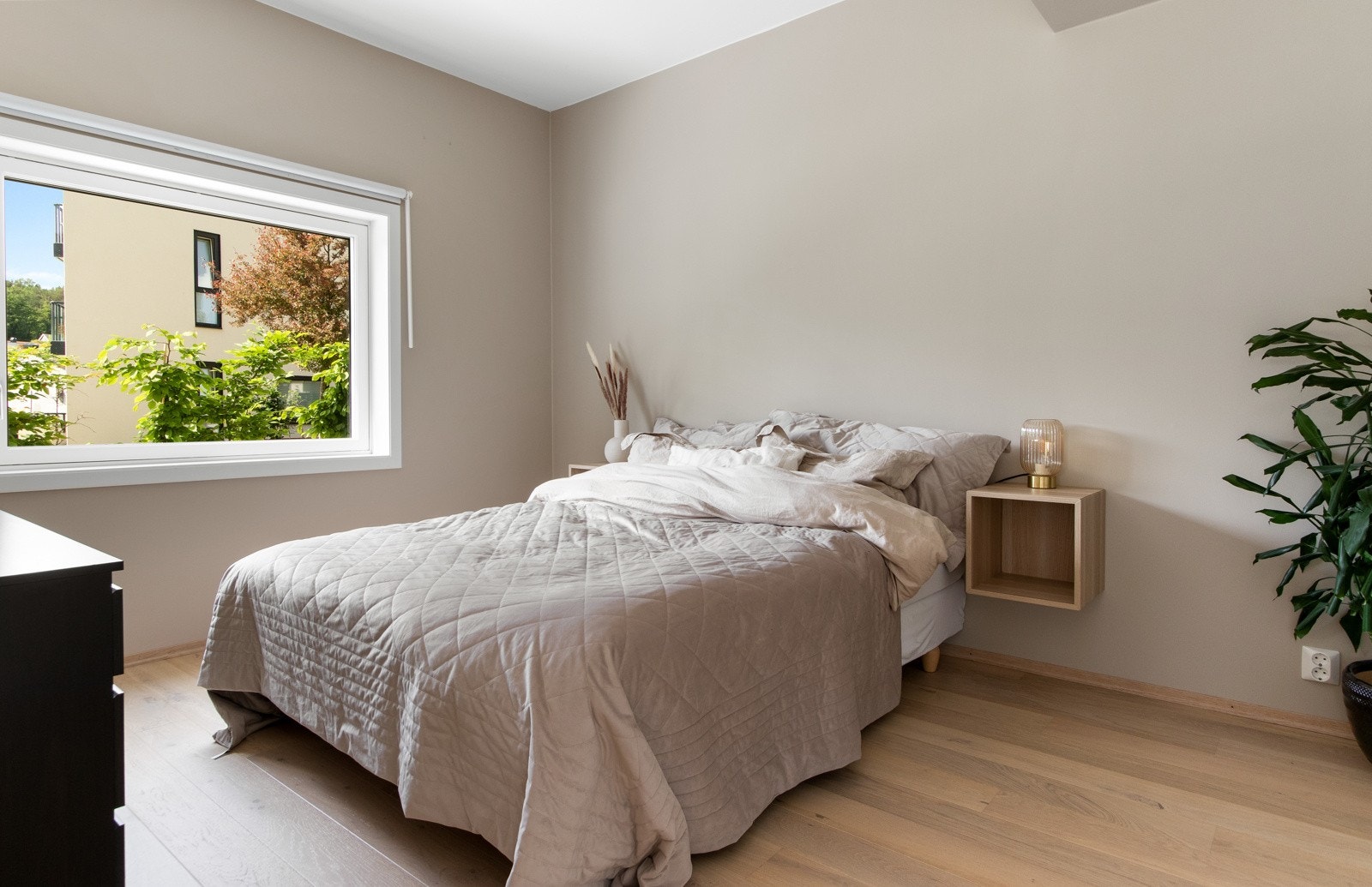 Det er plass til både dobbeltseng, garderobeløsning på flere vegger og annet møblement, og veggene er malt i en dus beigetone for en behagelig atmosfære. Galleribilde