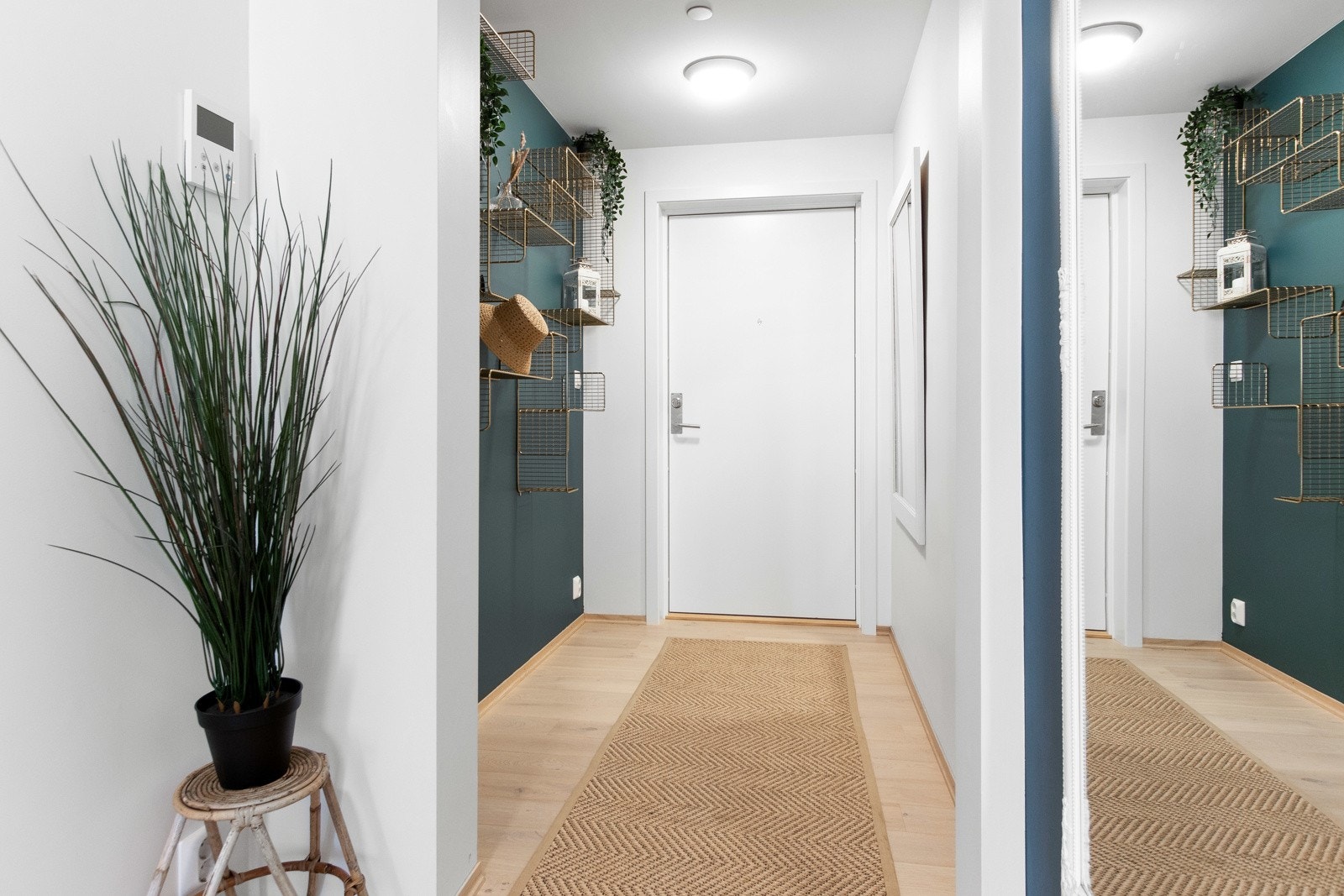 Både entreen og gangen har gulvvarme og en fin kontrastvegg malt i mørke trendfarger. Galleribilde