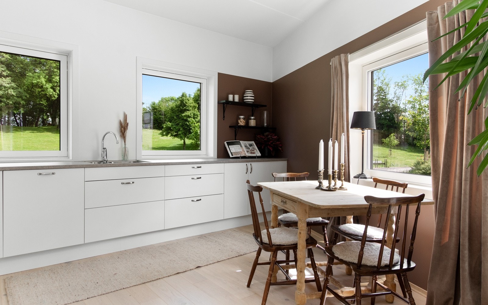 Kjøkkenet er stilrent og moderne, oppført i en funksjonell L-form med god arbeidsflyt og strålende utsikt over alt det grønne utenfor. Galleribilde