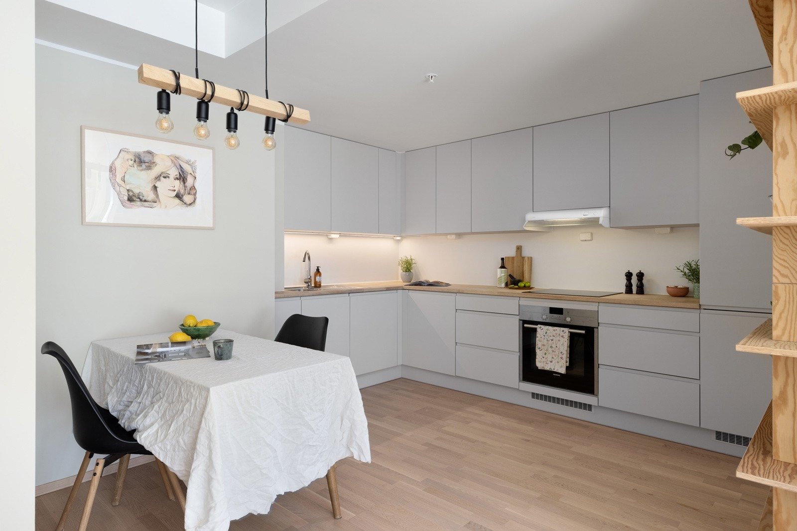 Kjøkkeninnredningen fra Arens har hvite, slette fronter og benkeplate i heltre med nedfelt oppvaskkum. Galleribilde