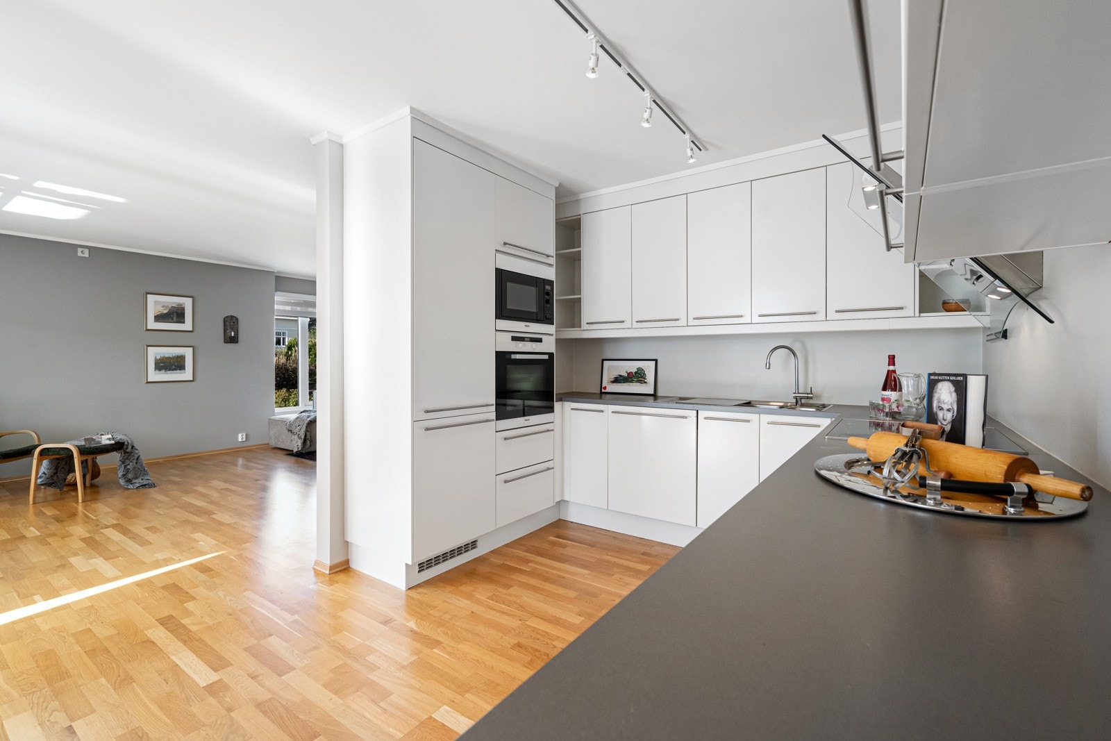 Kjøkkeninnredningen har laminerte skrog og glatte fronter. Laminert benkeplate med kjøkkenkum. Galleribilde