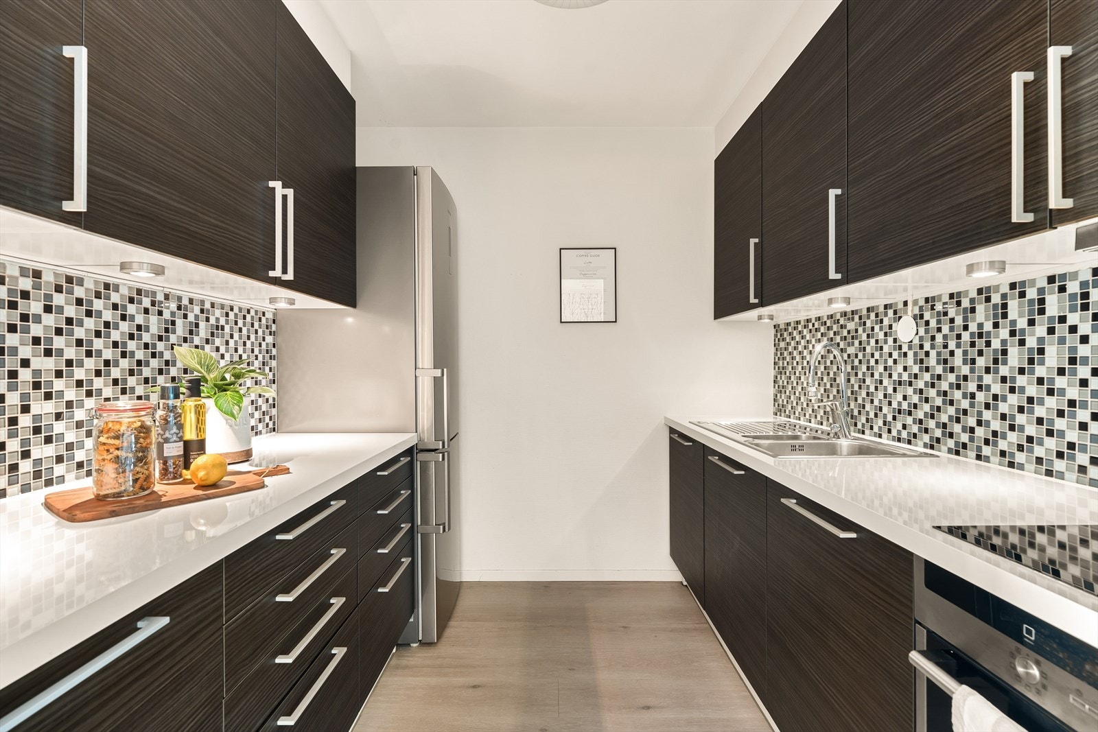 Kjøkkeninnredning med glatte fronter og laminat benkeplate Galleribilde