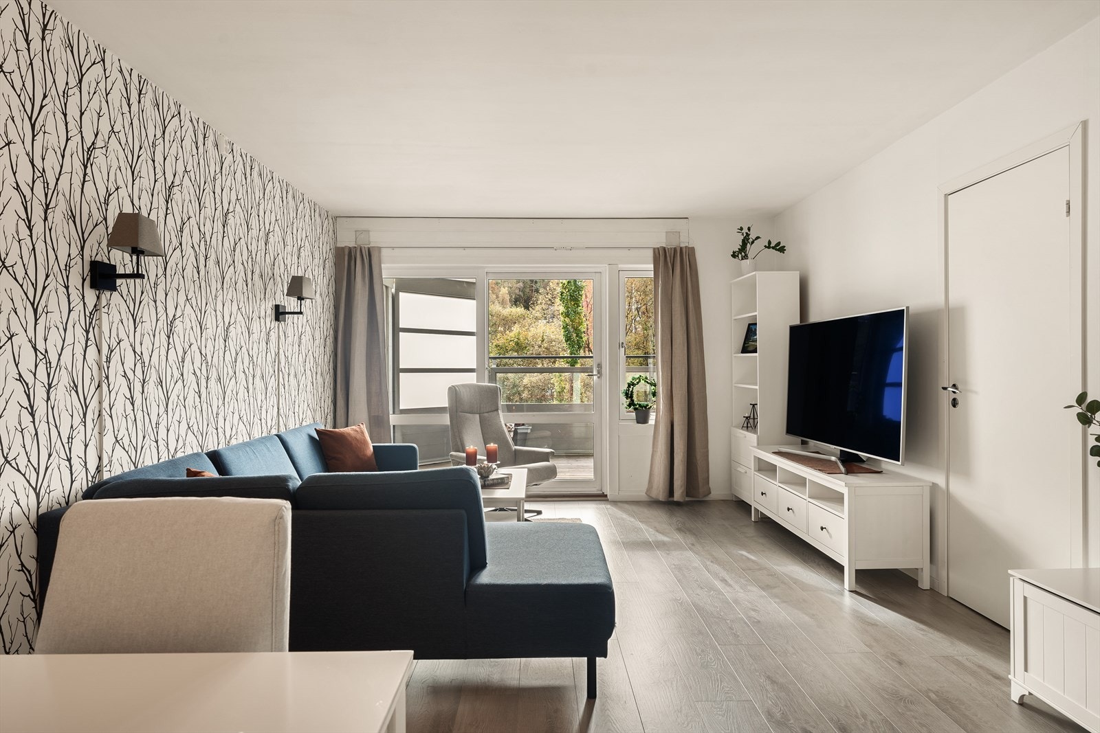 Store vindusflater sørger for godt med dagslys og hjelper til med å gjøre dette til et trivelig oppholdsrom Galleribilde