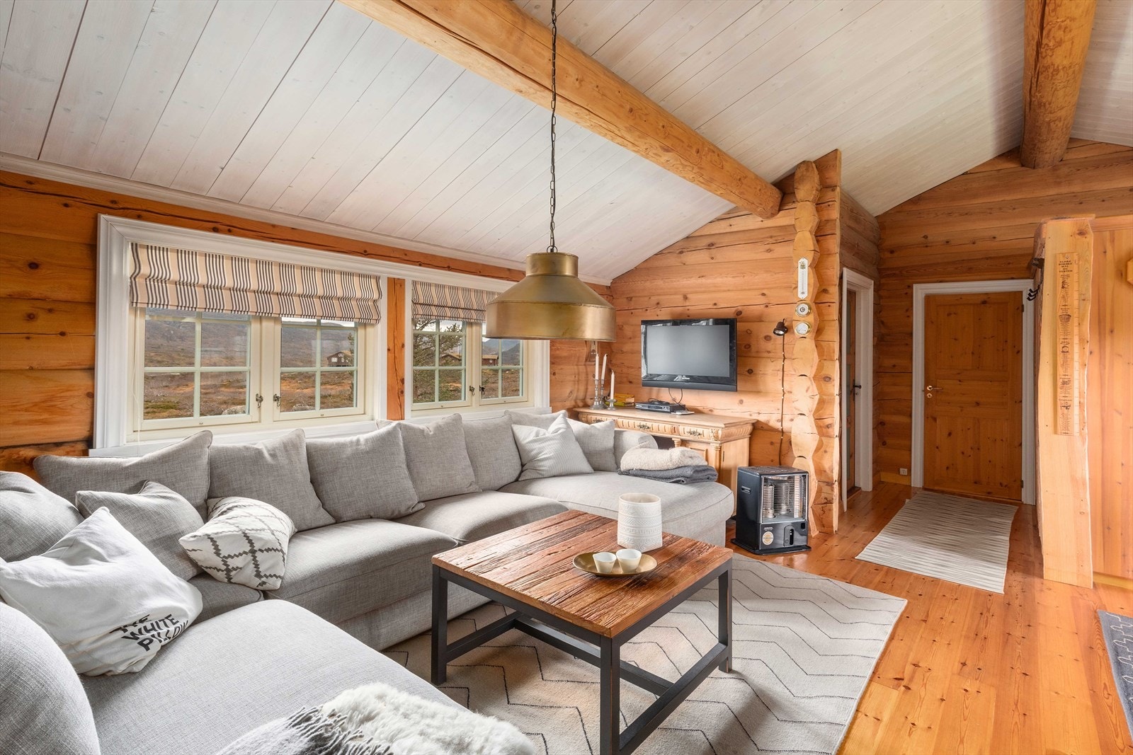 Hytta har en røff stil med solide tømmervegger og dragere i himlingen. Galleribilde