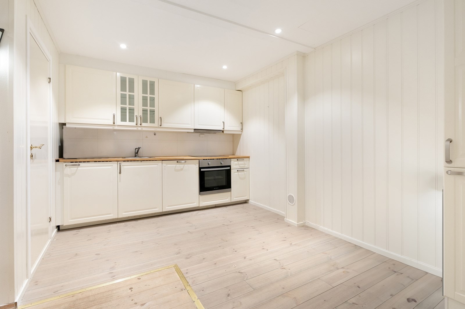 Kjøkkeninnredning i underetasje med laminerte skrog og profilerte fronter, samt integrerte hvitevarer og waterguard Galleribilde