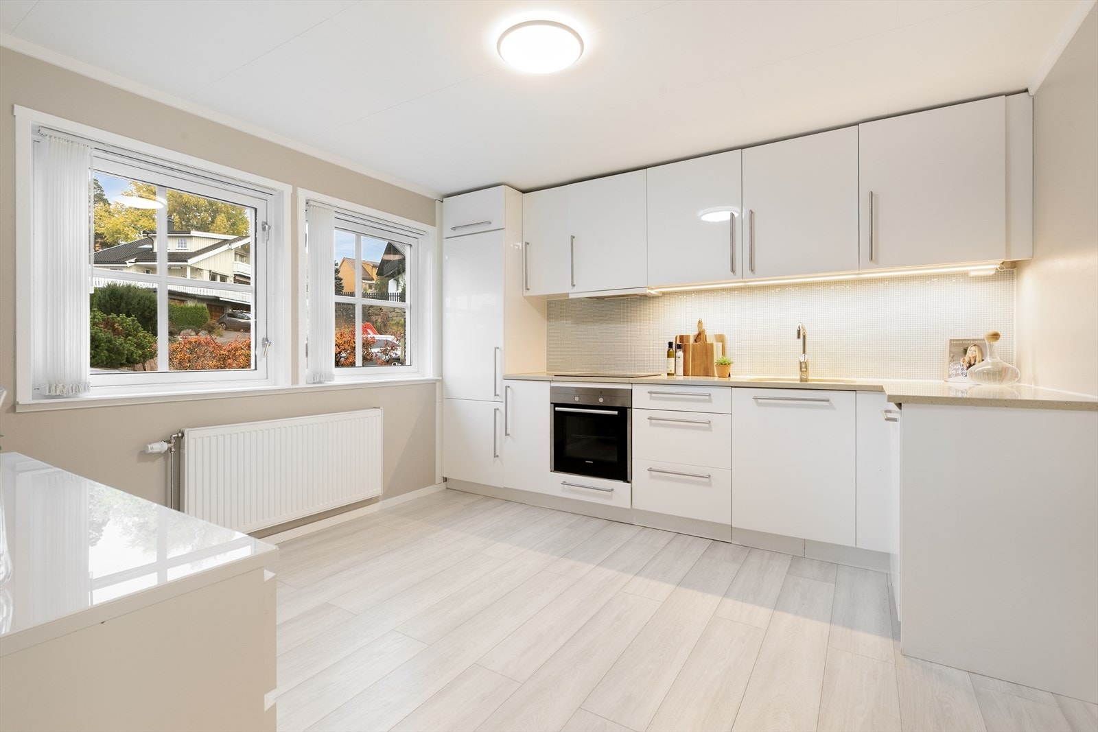 Stort og separat kjøkken i 1.etg med laminerte og glatte fronter, waterguard og integrerte hvitevarer Galleribilde