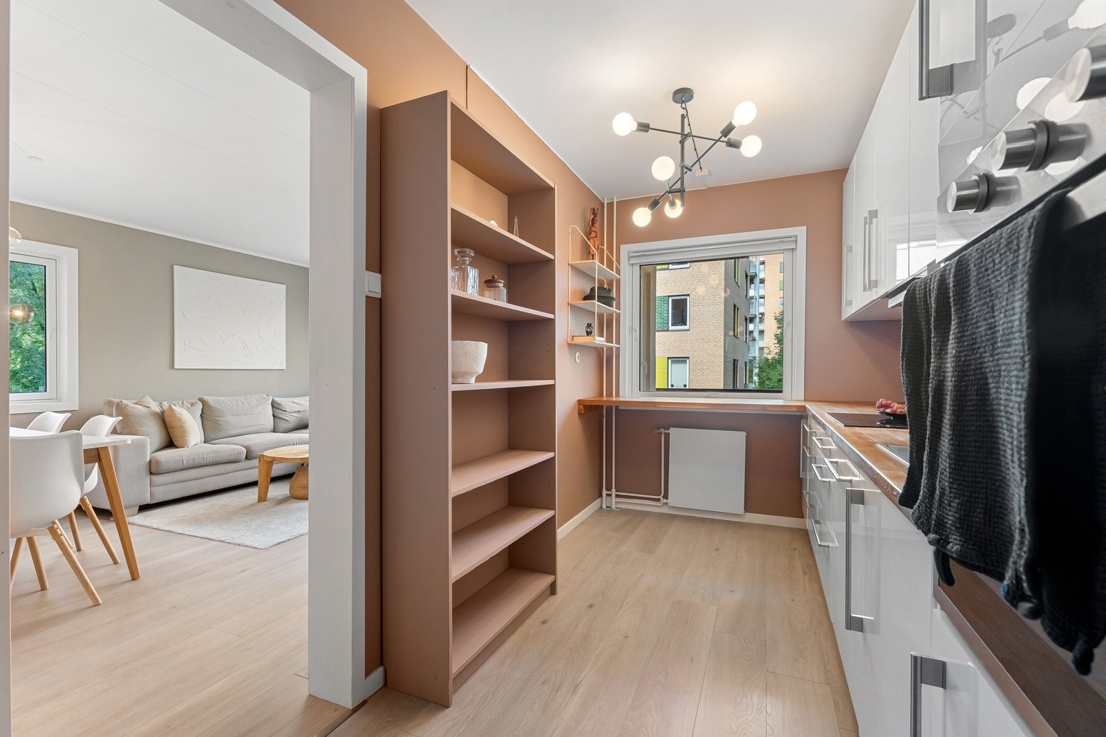 Lekkert og moderne kjøkken som består av hvite fronter og benkeplate i heltre. Galleribilde