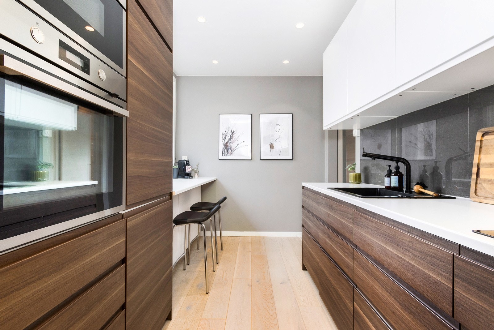 Kjøkkeninnredningen fra 2019 har mørke og hvite glatte fronter. Benkeplaten er i laminat med nedfelt oppvaskkum. Galleribilde