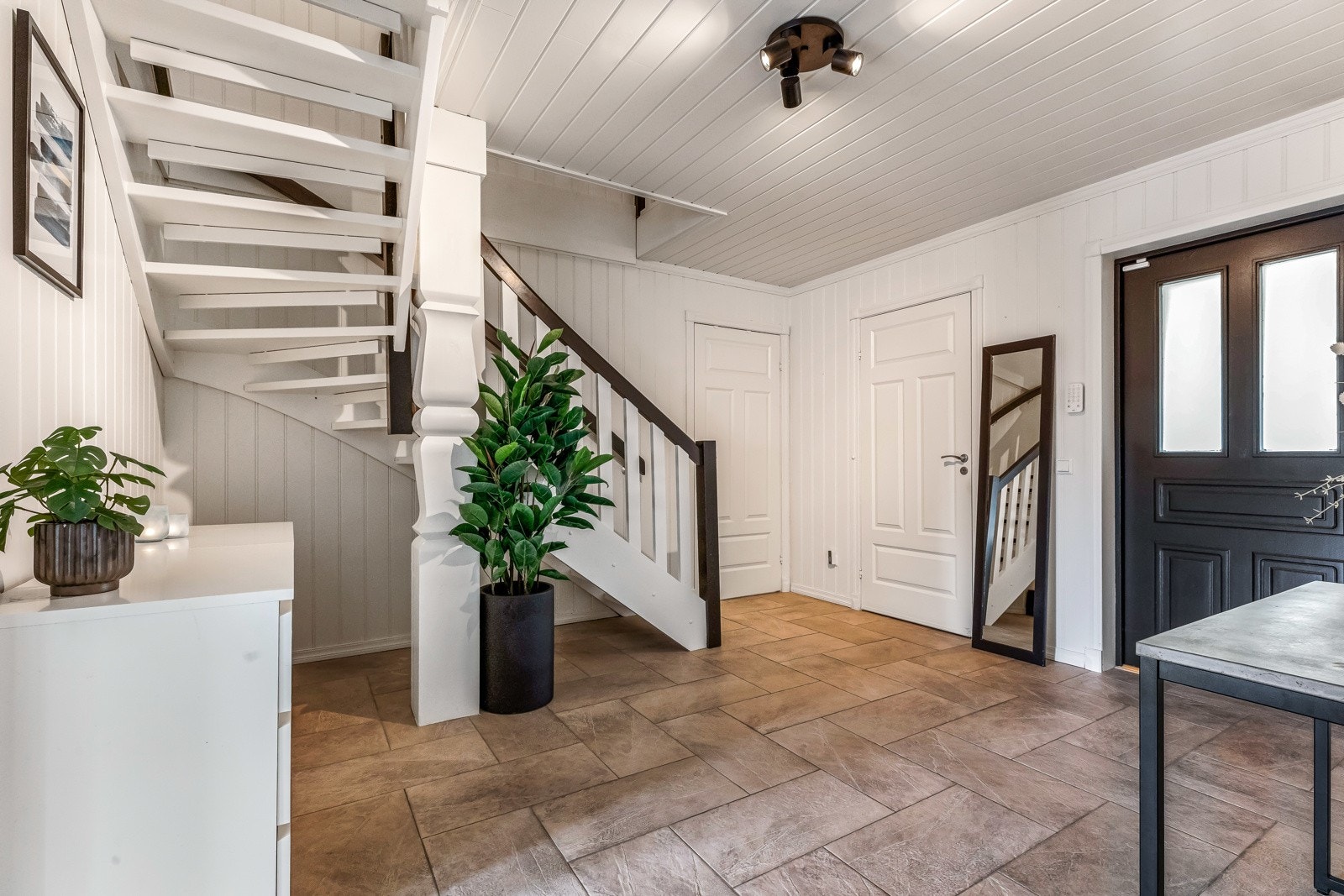 Entré i første etasje har flislagte gulv og panel på vegger Galleribilde