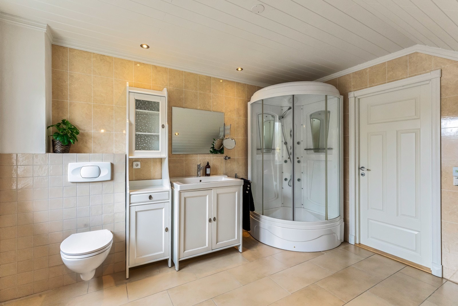 Innredning med underskap og nedfelt servant. Vegghengt toalett og hjørnebadekar samt dusjkabinett(steamdusj). Galleribilde