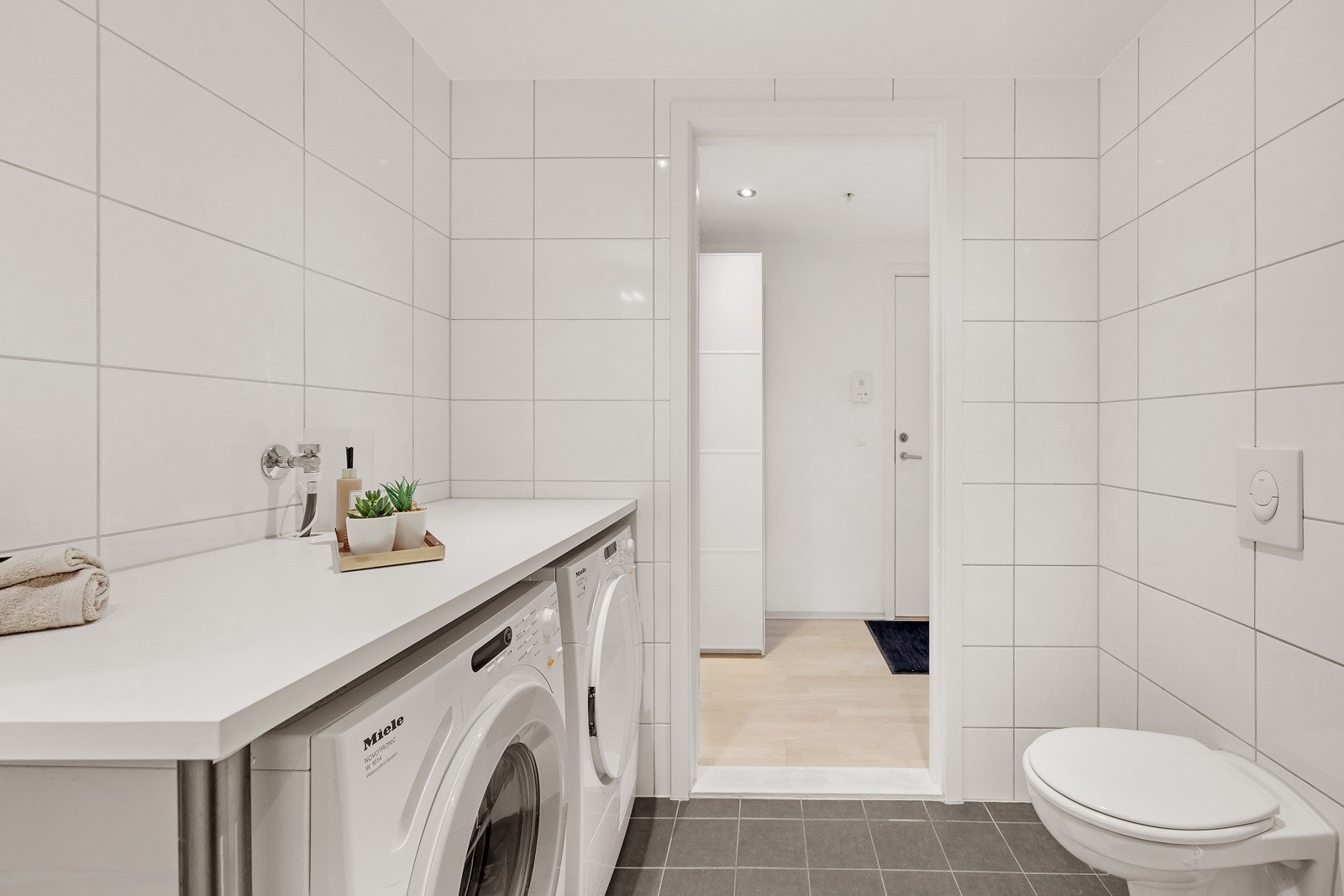 Badet har opplegg for vaskemaskin. Det er laget egen benkeplass over for mulighet for ekstra oppbevaring Galleribilde