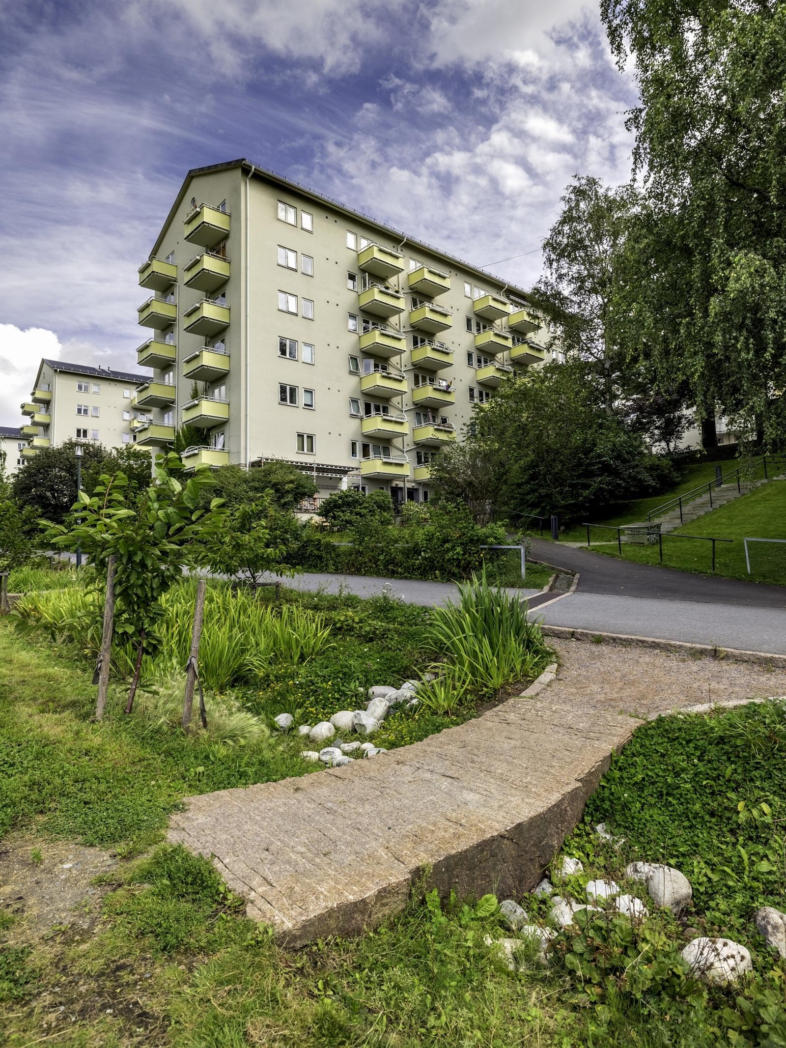 Leiligheten har Iladalen som nærmeste nabo. (Bilde av Vøyensvingen 16D fra Iladalen, en av leilighetene i fjerde etasje var det brann i Februar 2024. Noe av fasaden er retusjert). Galleribilde