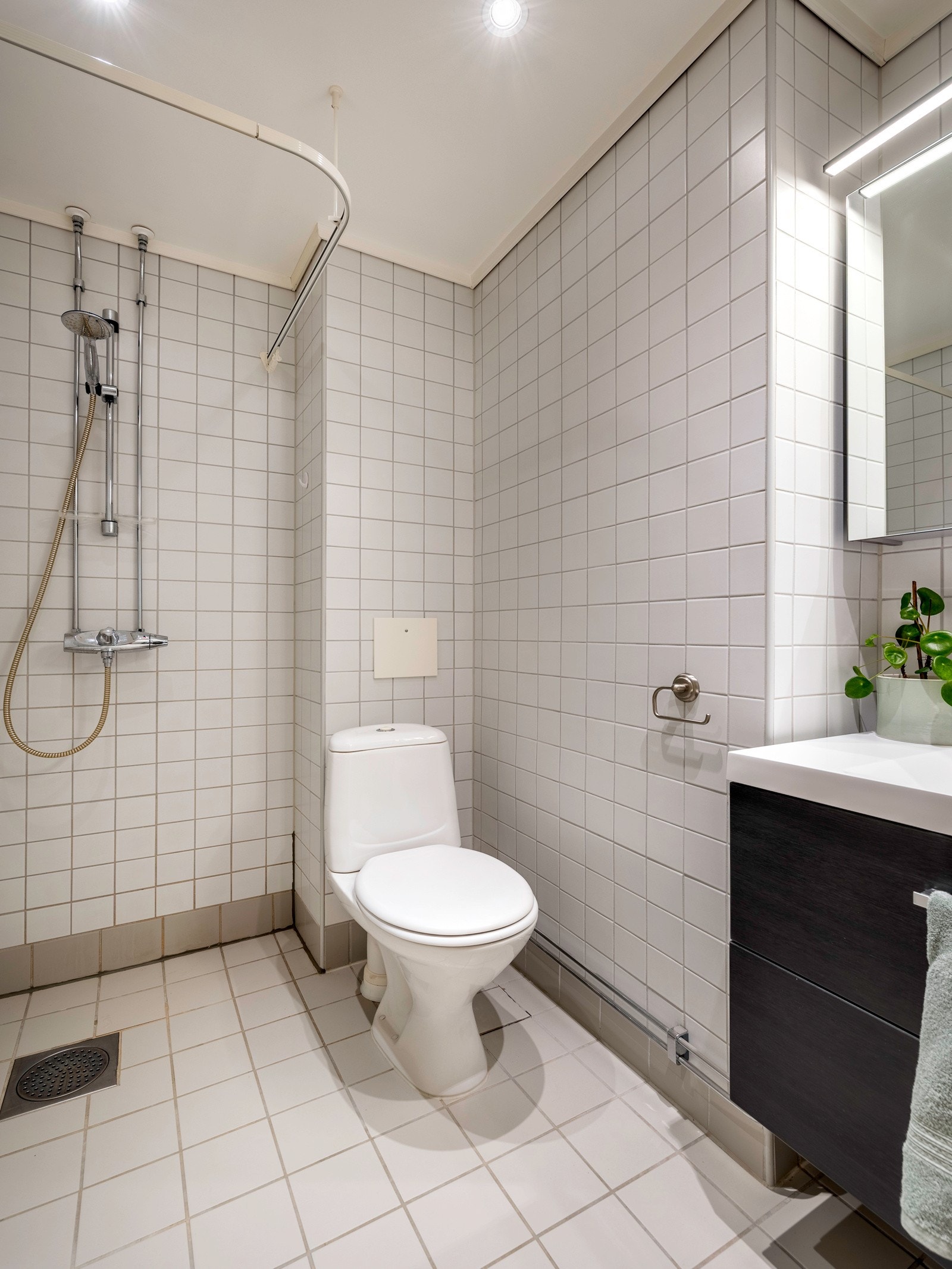 Baderommet har flislagte overflater både på veggene og gulvet, noe som gir et moderne og stilrent inntrykk samtidig som det er enkelt å vedlikeholde. Galleribilde