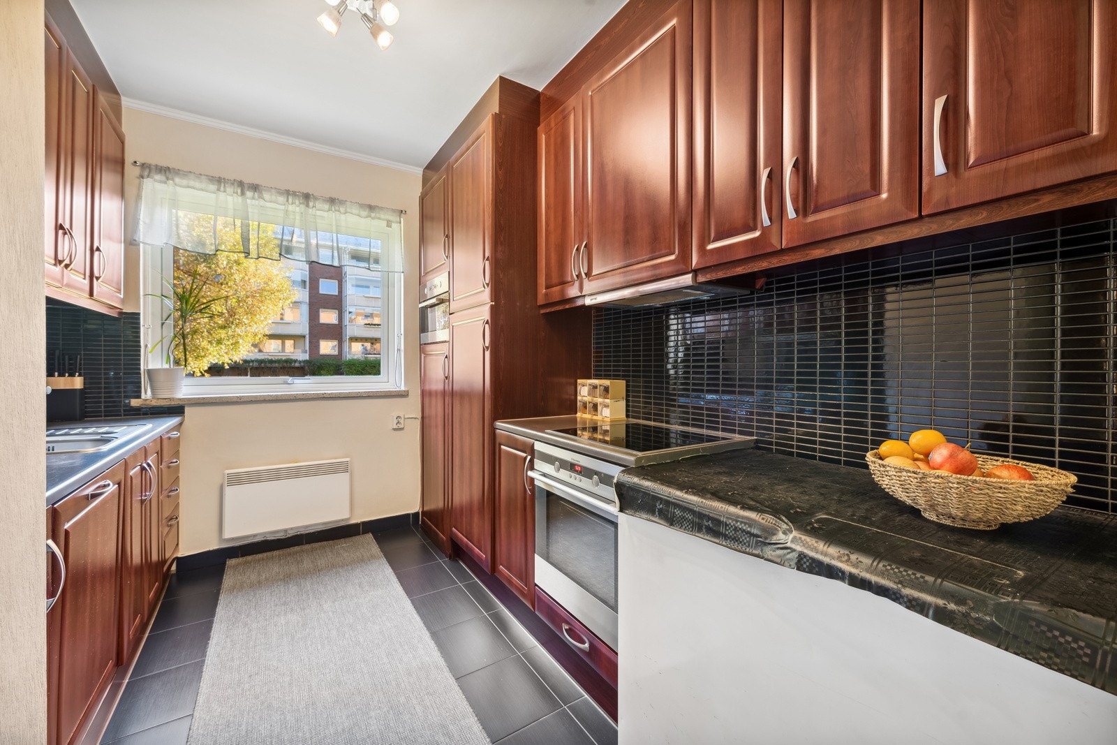 Kjøkken med integrert oppvaskmaskin, komfyr, mikroovn og kjøleskap. Galleribilde