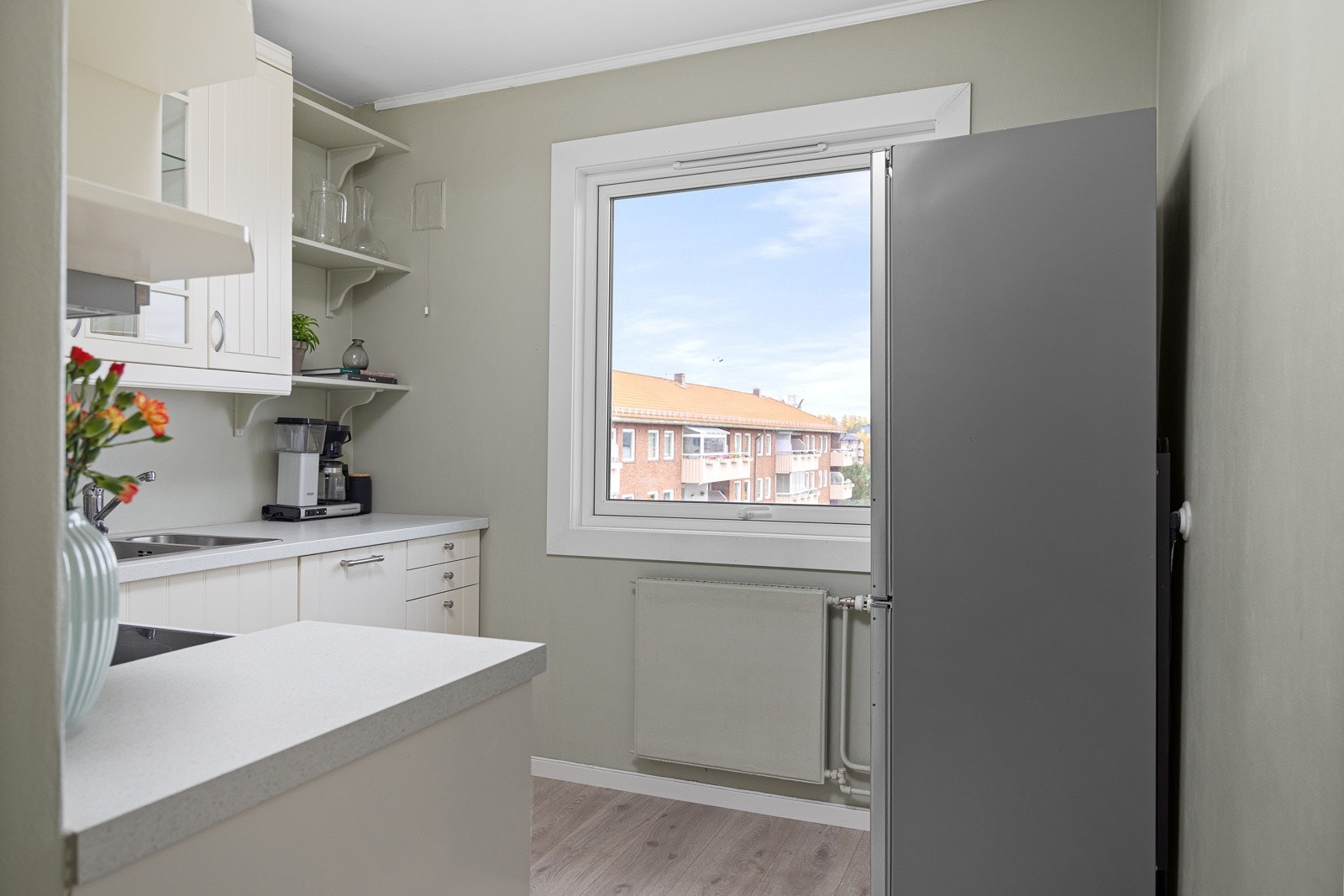 Lys og tidløs kjøkkeninnredning med integrert oppvaskmaskin. Galleribilde