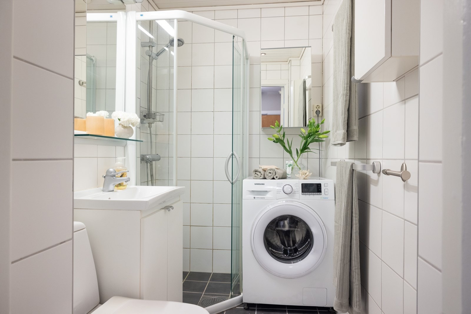 Badet er innredet med klosett, servant med innredning og dusjhjørne med skyvbar glassdører. Galleribilde