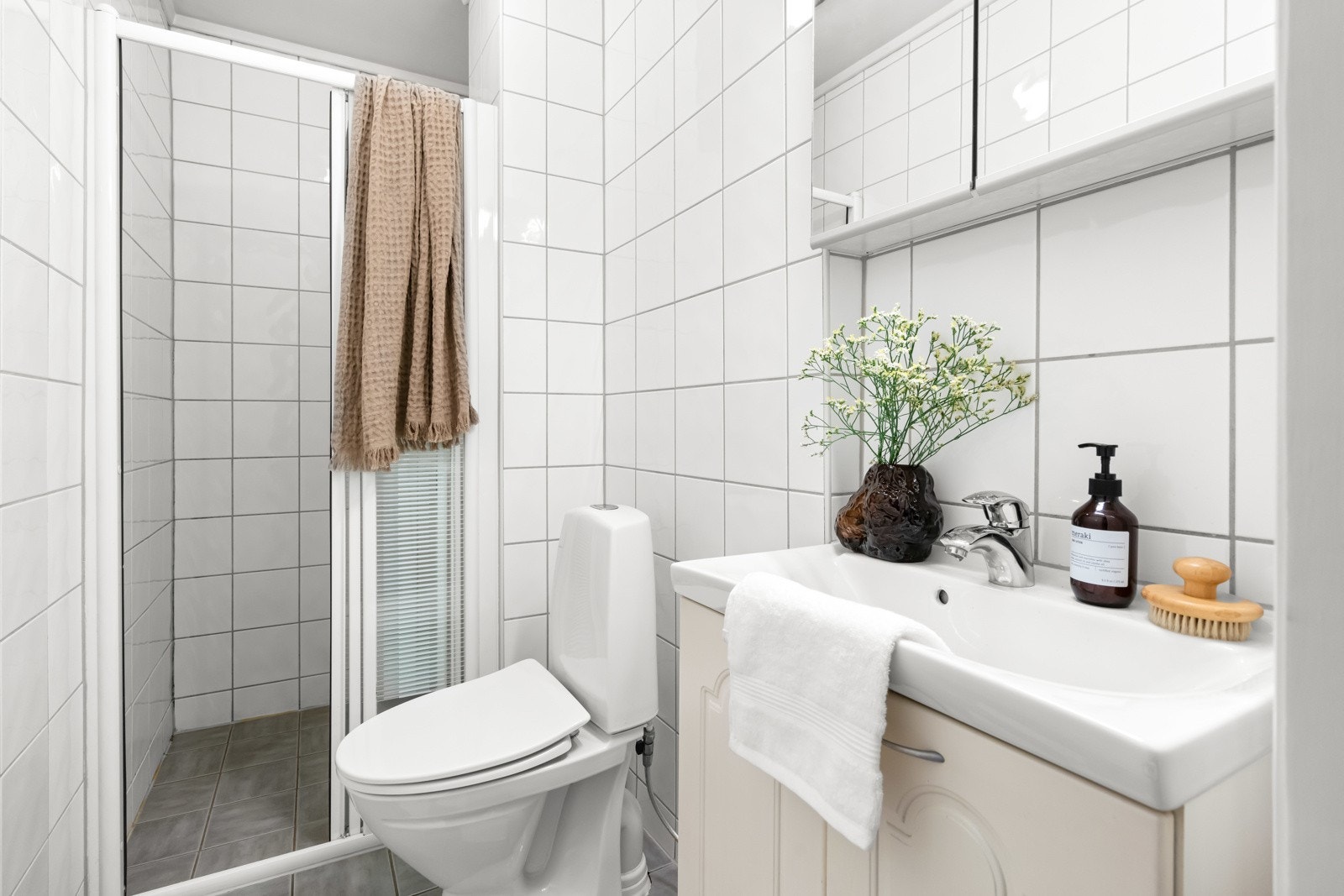 Flislagt baderom fra 2005 med dusjnisje, servant og gulvstående toalett. Galleribilde