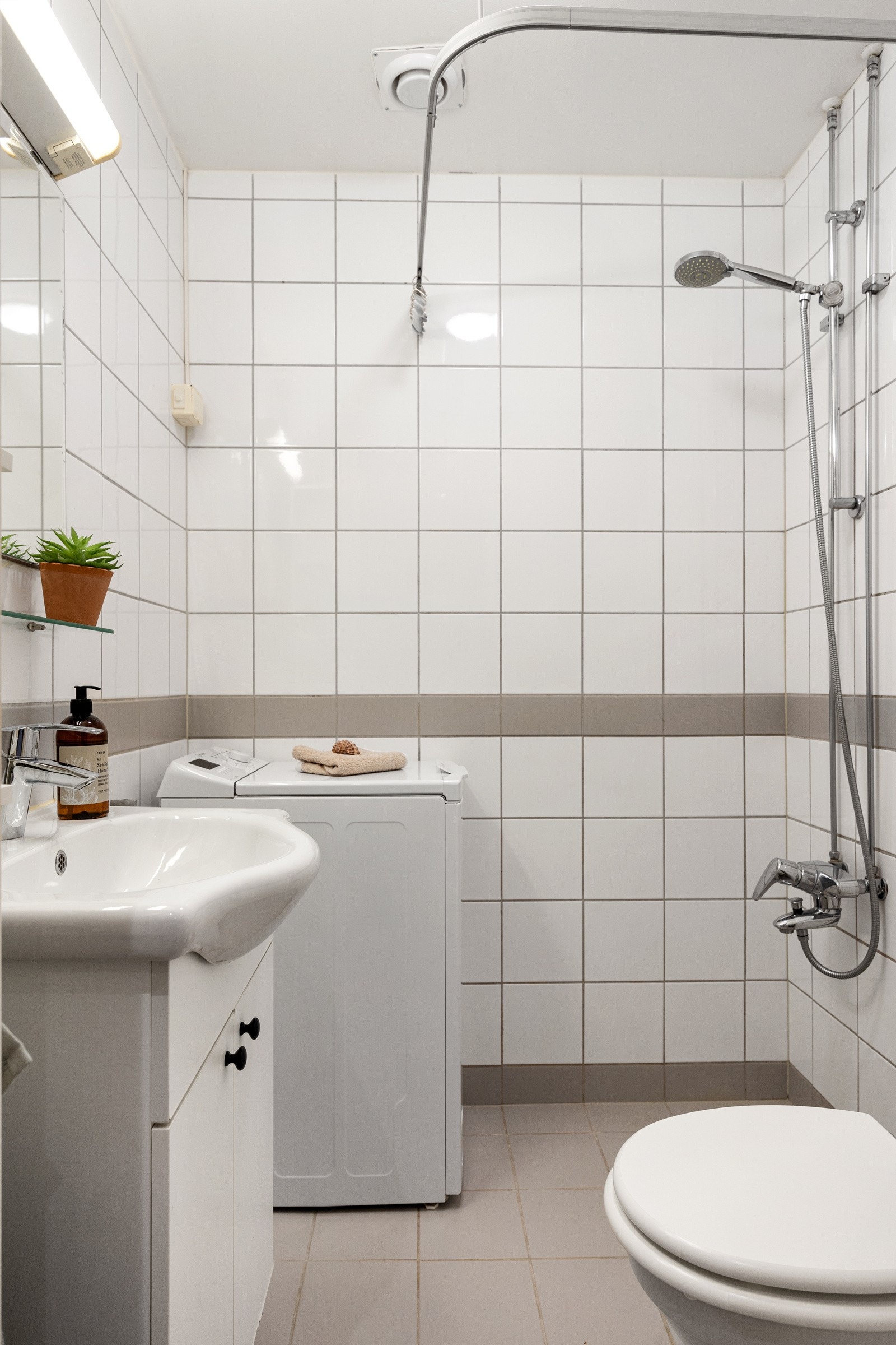 Flislagt bad med gulvvarme og opplegg for vaskemaskin. Galleribilde