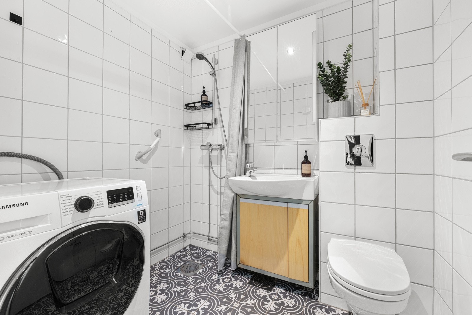 Badet ble oppgradert i 2023, og har led-downlights, hvite veggfliser og opplegg for vaskemaskin Galleribilde