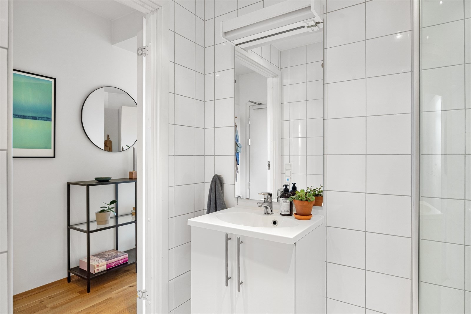 Badet består av servantskap med nedfelt servant, speil med lys over, vegghengt klosett med innebygd sisterne, dusjsone med innfelte dusjdører i herdet glass. Galleribilde
