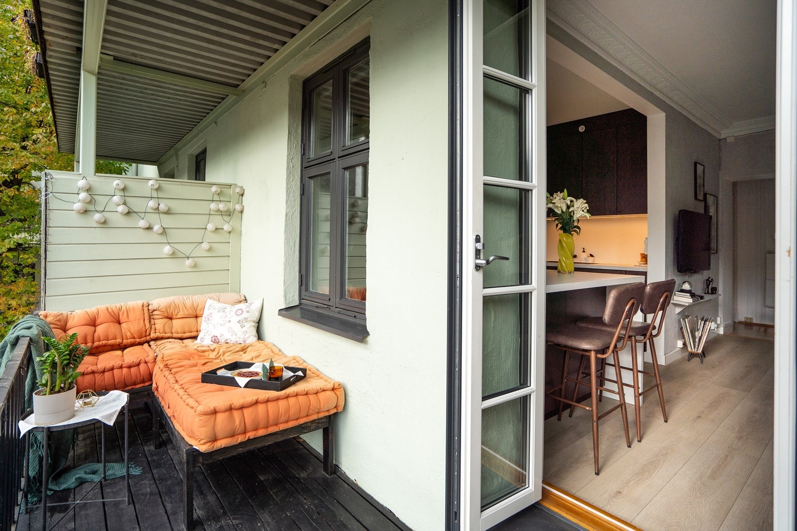 Balkongen har tredekke, metallrekkverk og skillevegg i tre, mens doble glassdører fra 2019 sørger for en flytende overgang mellom inne- og uteområdet. Galleribilde