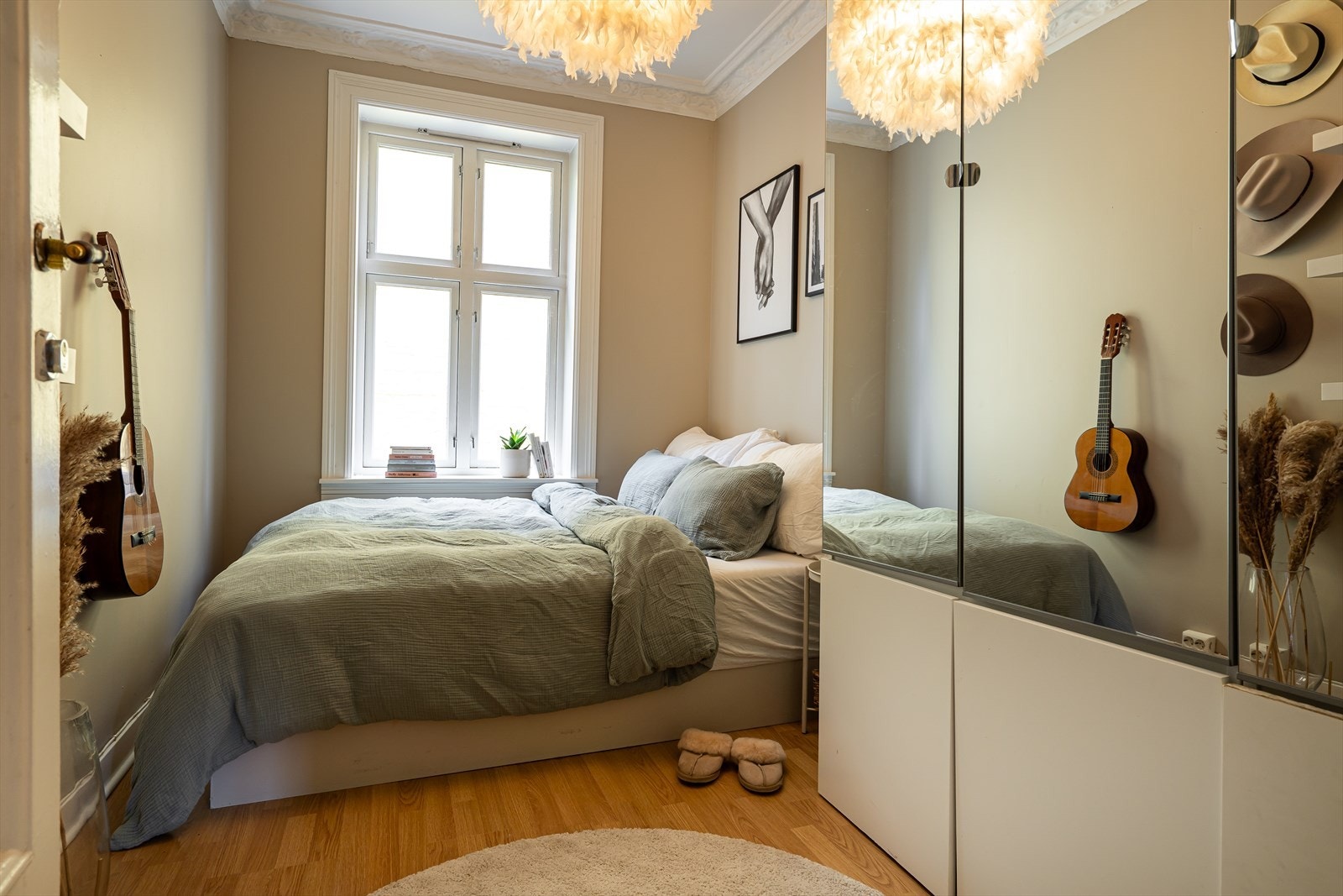 Vinduet vender mot rolige fellesarealer, og den klassiske stukkaturen og rosetten i taket gir rommet et tidløst og elegant preg. Galleribilde