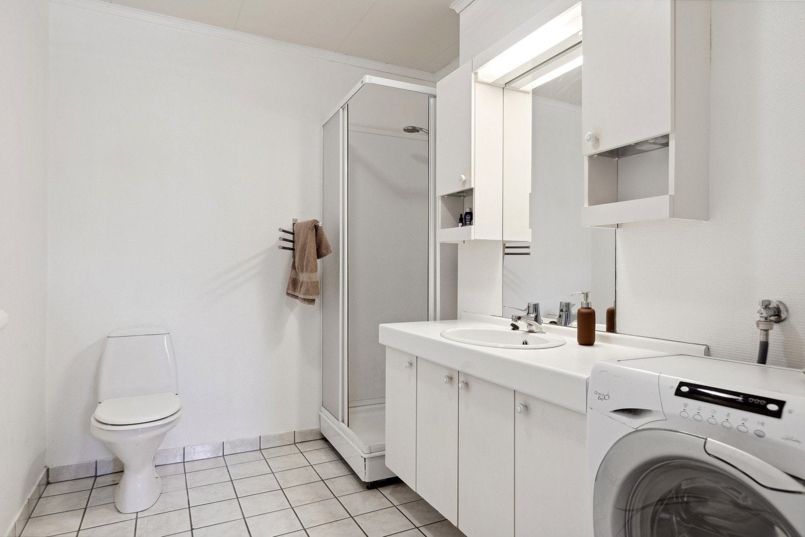 Badet til utleiedelen har eget dusjkabinett og opplegg til vaskemaskin. Galleribilde