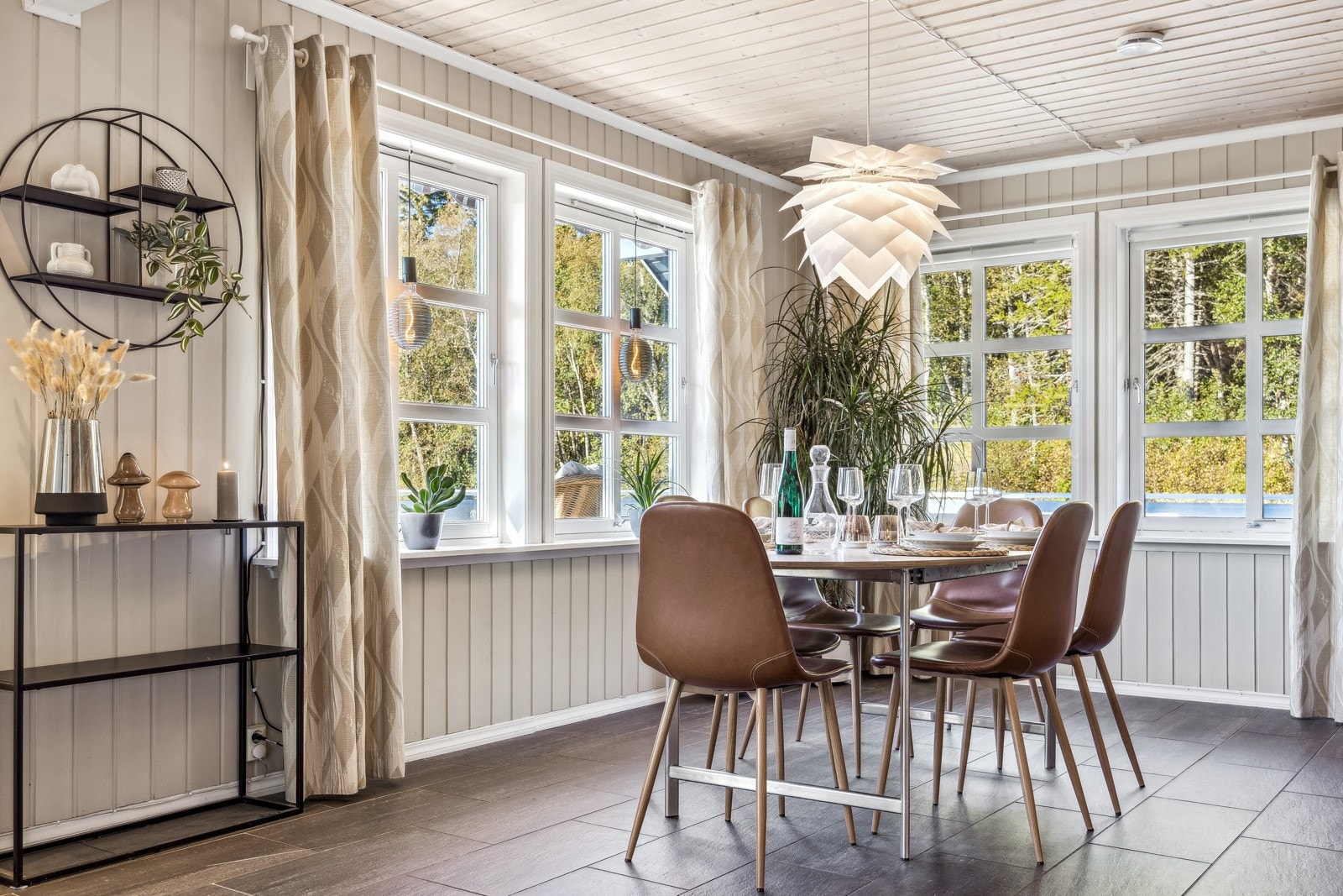 Spisestuen har store vindusflater som gir mye naturlig lys og en koselig atmosfære. Galleribilde