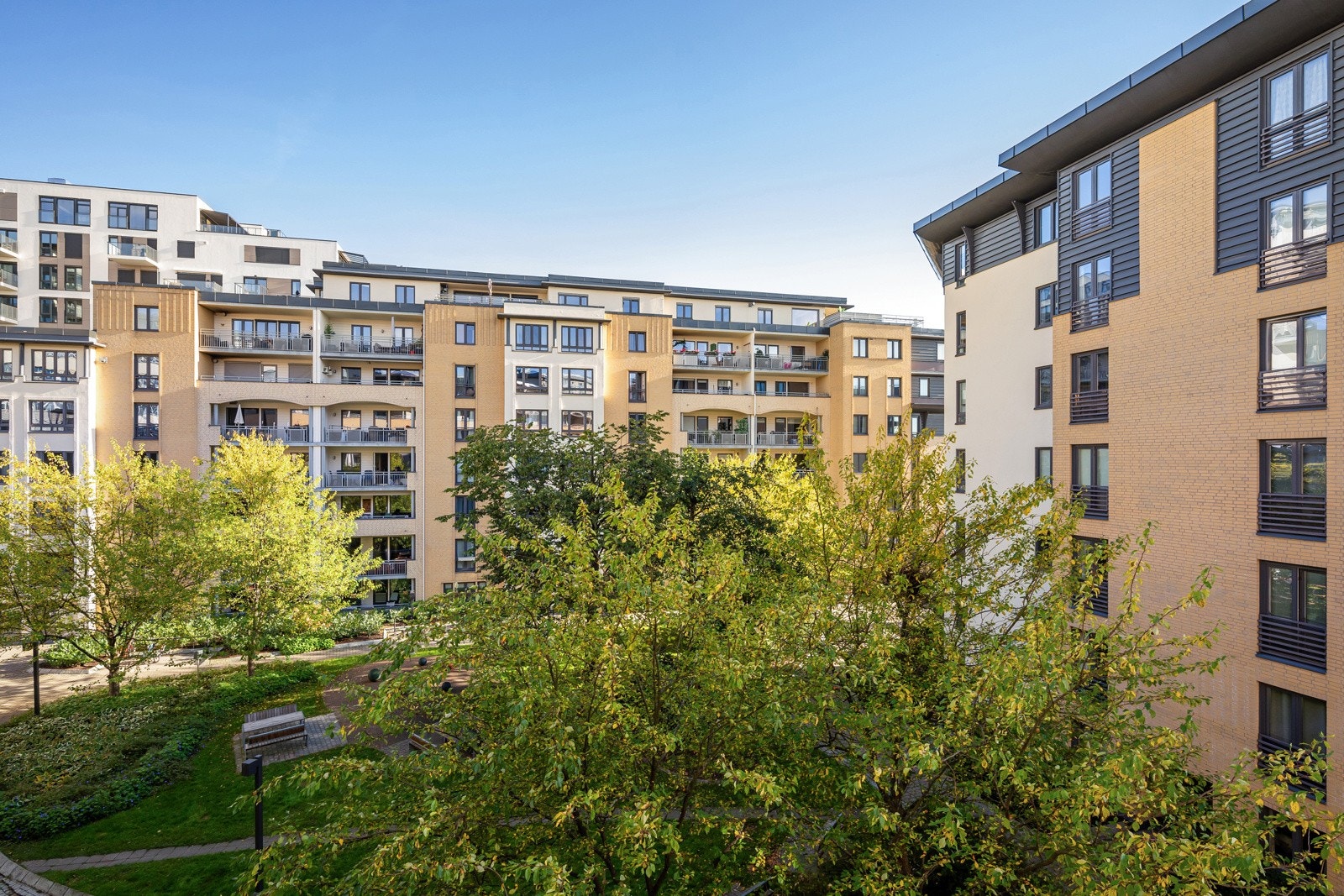 Vender mot rolig gate og frodig bakgårdsmiljø. Galleribilde