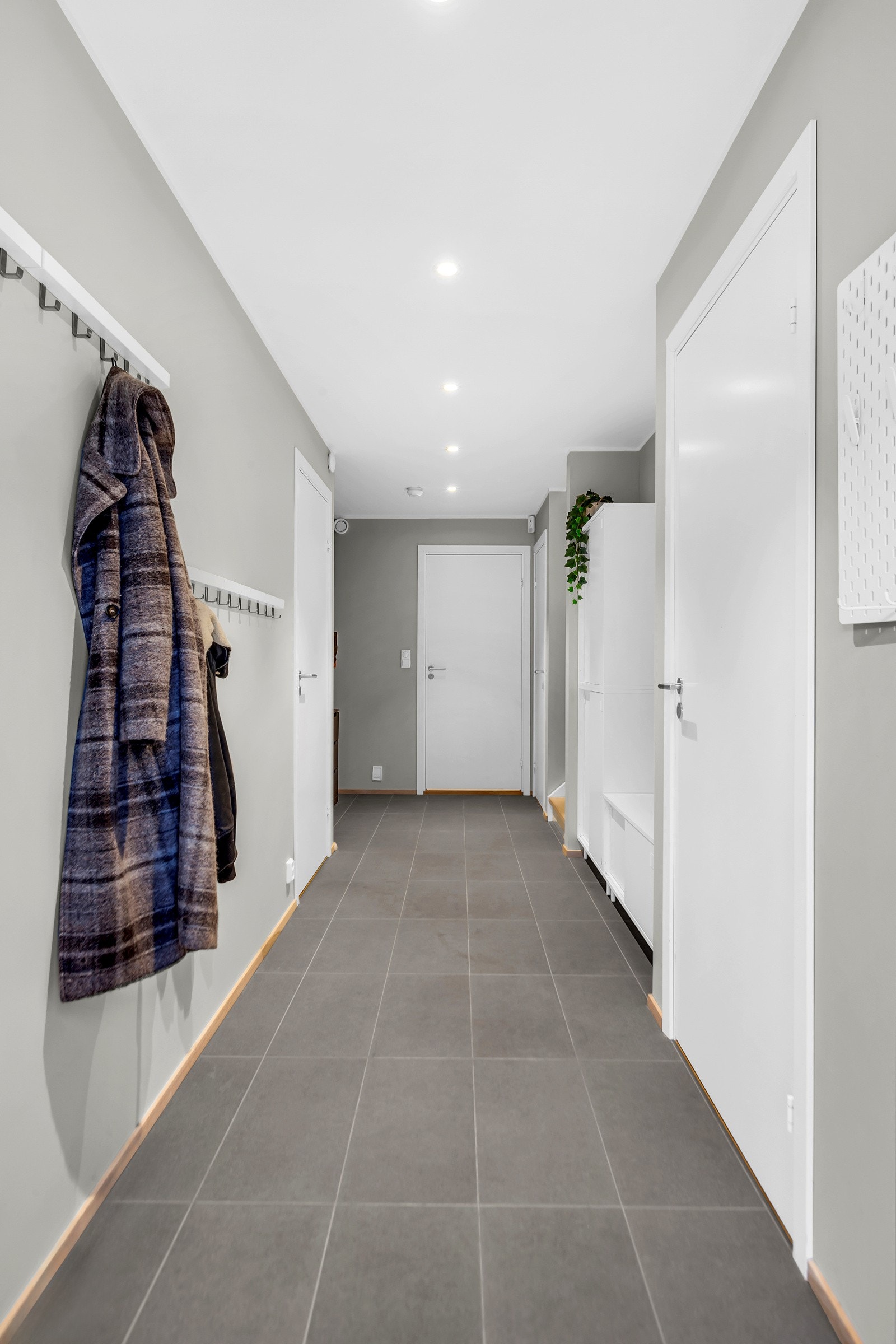 Inn i boligen ønskes du velkommen til en moderne og lys entré. Her har du plass til kommode og garderobe for oppbevaring av sko og annet yttertøy. Galleribilde