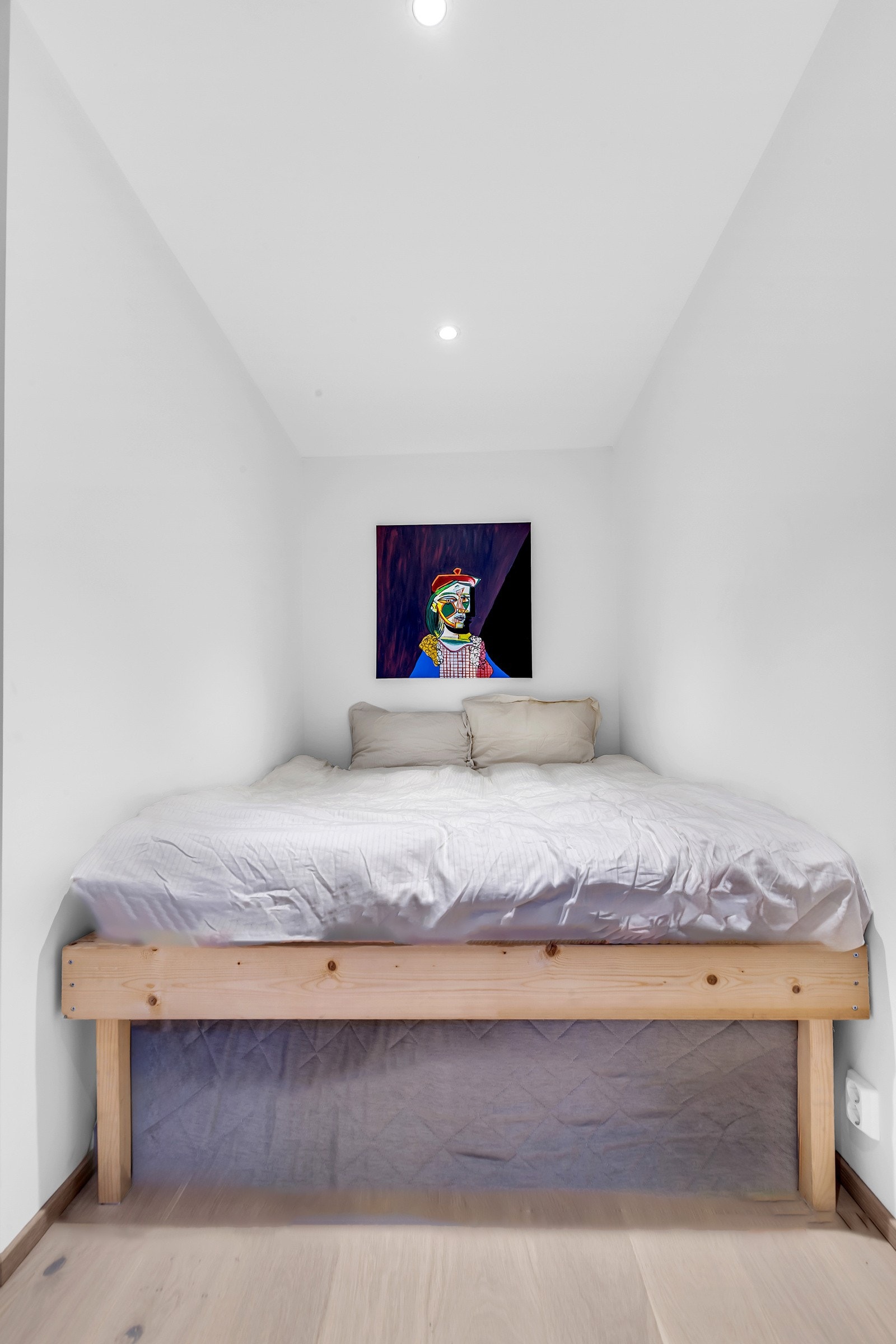 Det minste av de to soverommene nede har lys parkett på gulv og hvitmalte slette vegger og himling, med downlights i taket. Galleribilde
