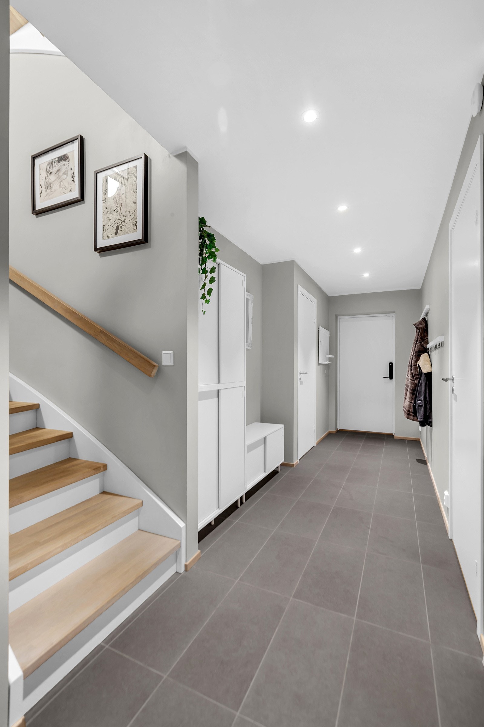 Entreén har hvitmalte slette vegger- og himling, med downlights i taket. Gulvet har tidløse grå fliser. Galleribilde