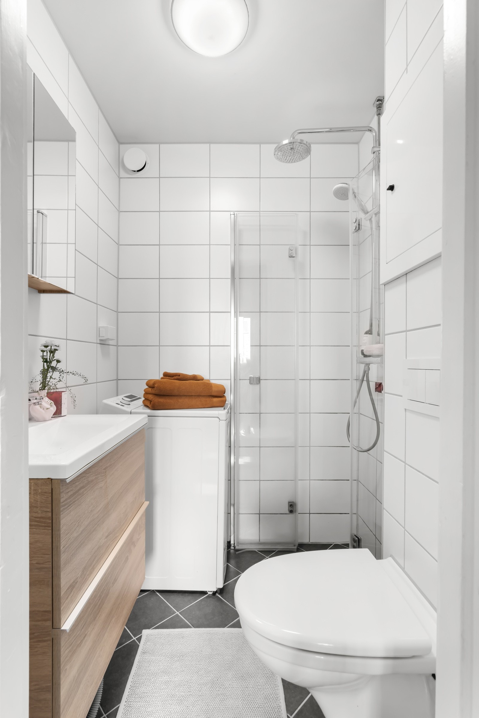 Innredningen består av dusj med innfellbare dører i glass, servant og veggfestet toalett. Galleribilde